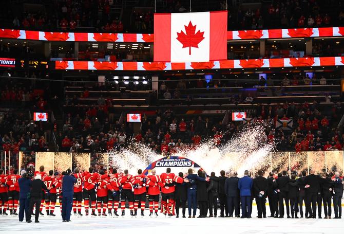 Team Canada stand together at center ice during postgame ceremonies.