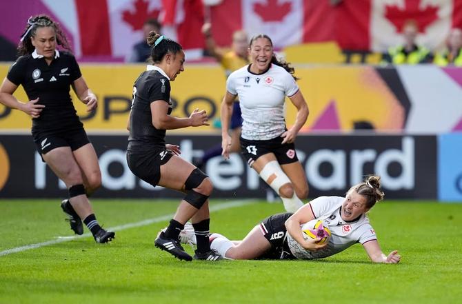 Canadian scrum half Justine Pelletier smiles as she touches the ground to the ball to score a try.