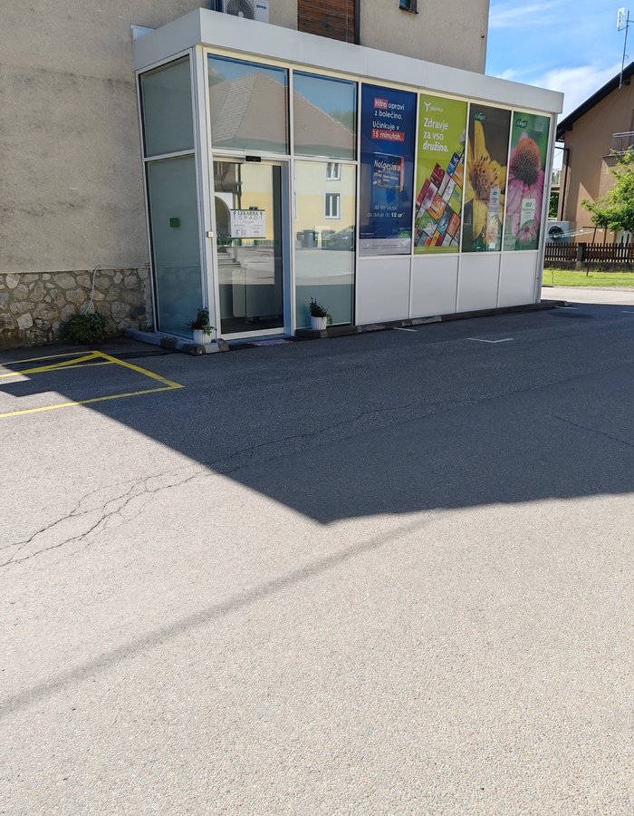 Lekarna Grad — širši pogled na zunanjost s parkiriščem in okolico