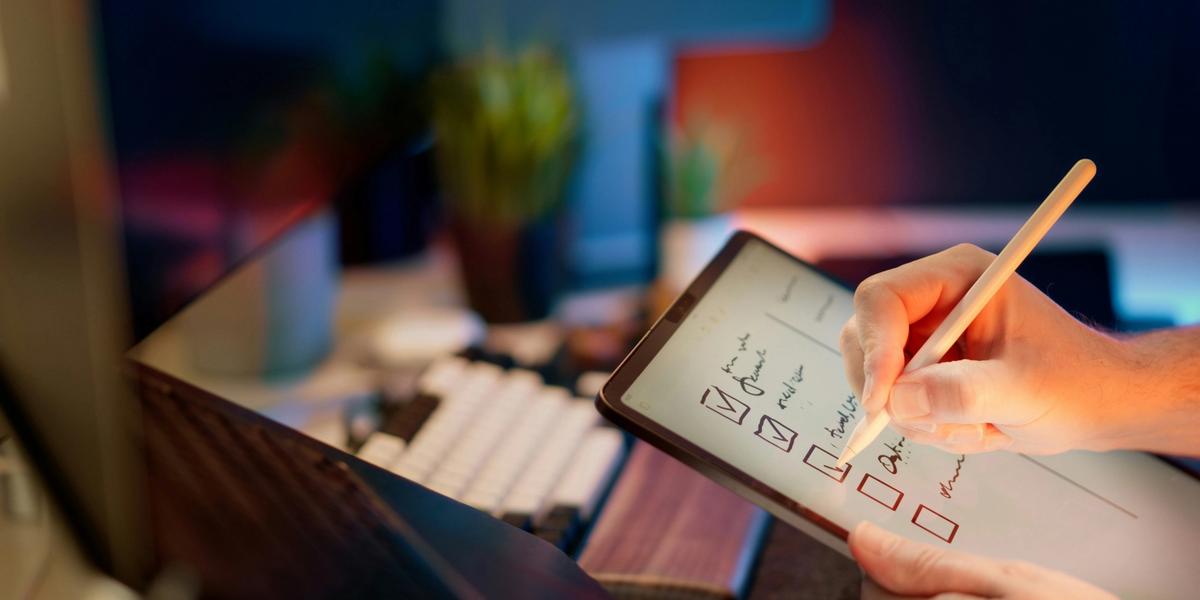 Escrevendo na tela de um tablet uma lista de itens a concretizar.