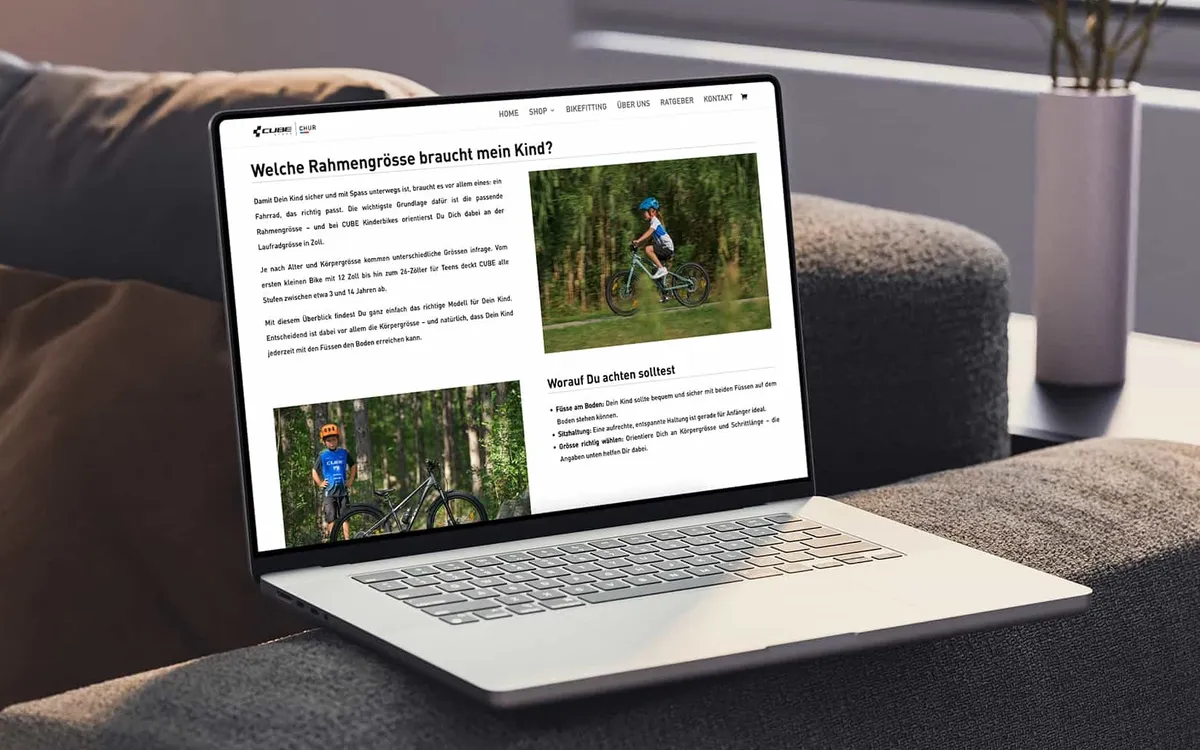 Website und Online-Shop: Laptop auf einem Sofa zeigt den Online-Ratgeber des CUBE Store Chur zur Rahmengröße für Kinderräder