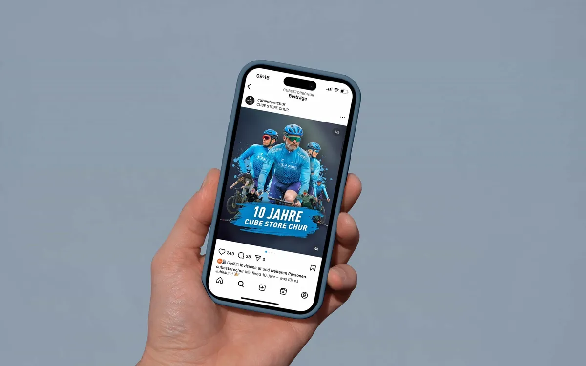 Marketing & Strategie: Hand hält ein Smartphone mit dem Kampagnenmotiv „10 Jahre CUBE Store Chur"