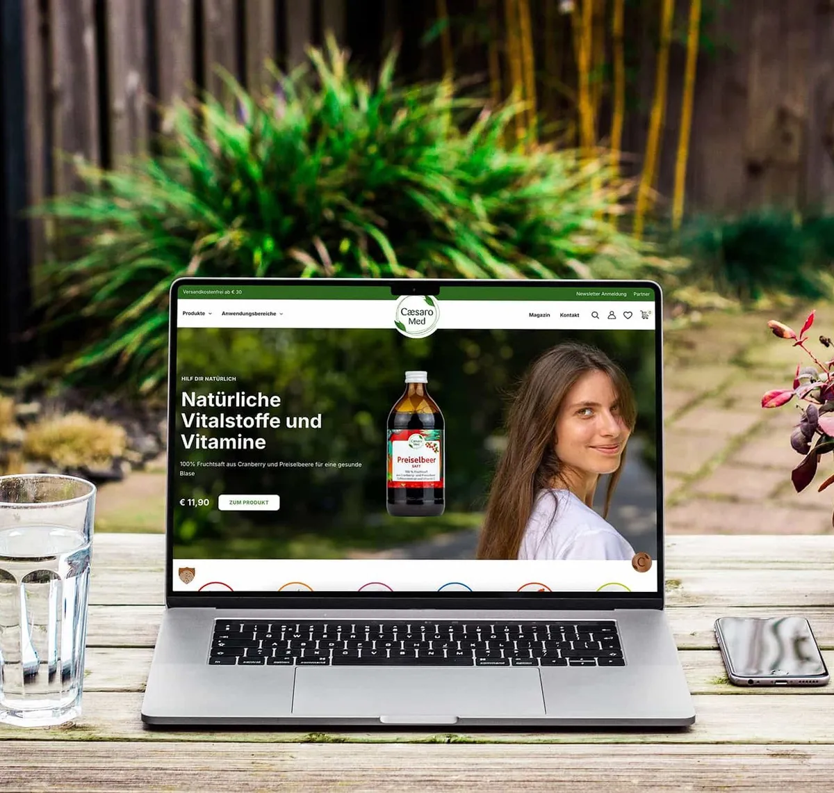 Caesaro Med: Laptop auf einem Gartentisch zeigt den Caesaro-Med-Shop mit der Zeile „Natürliche Vitalstoffe und Vitamine"