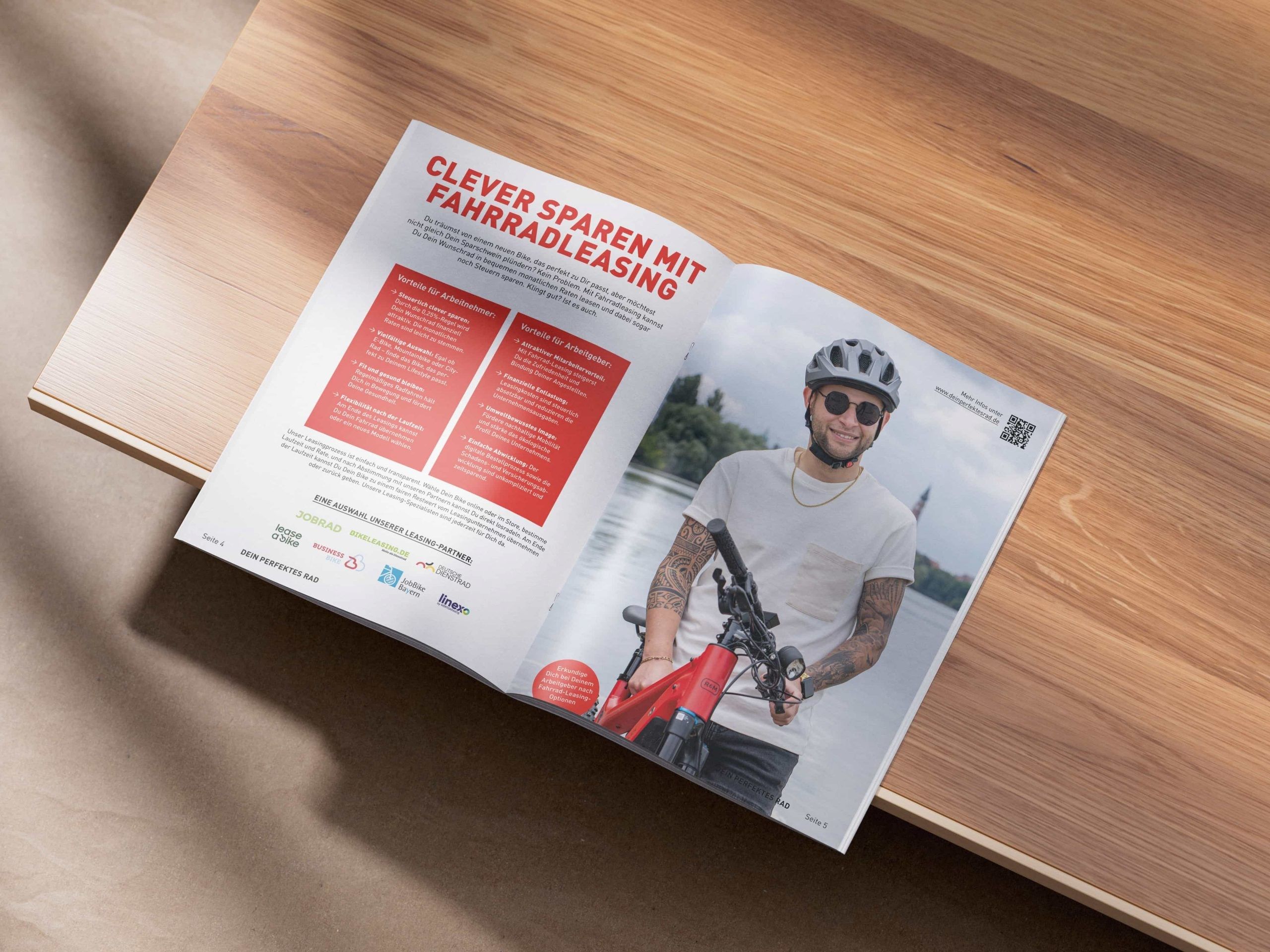 Dein perfektes Rad: Aufgeschlagenes Magazin auf einem Holztisch mit der Doppelseite „Clever sparen mit Fahrradleasing"