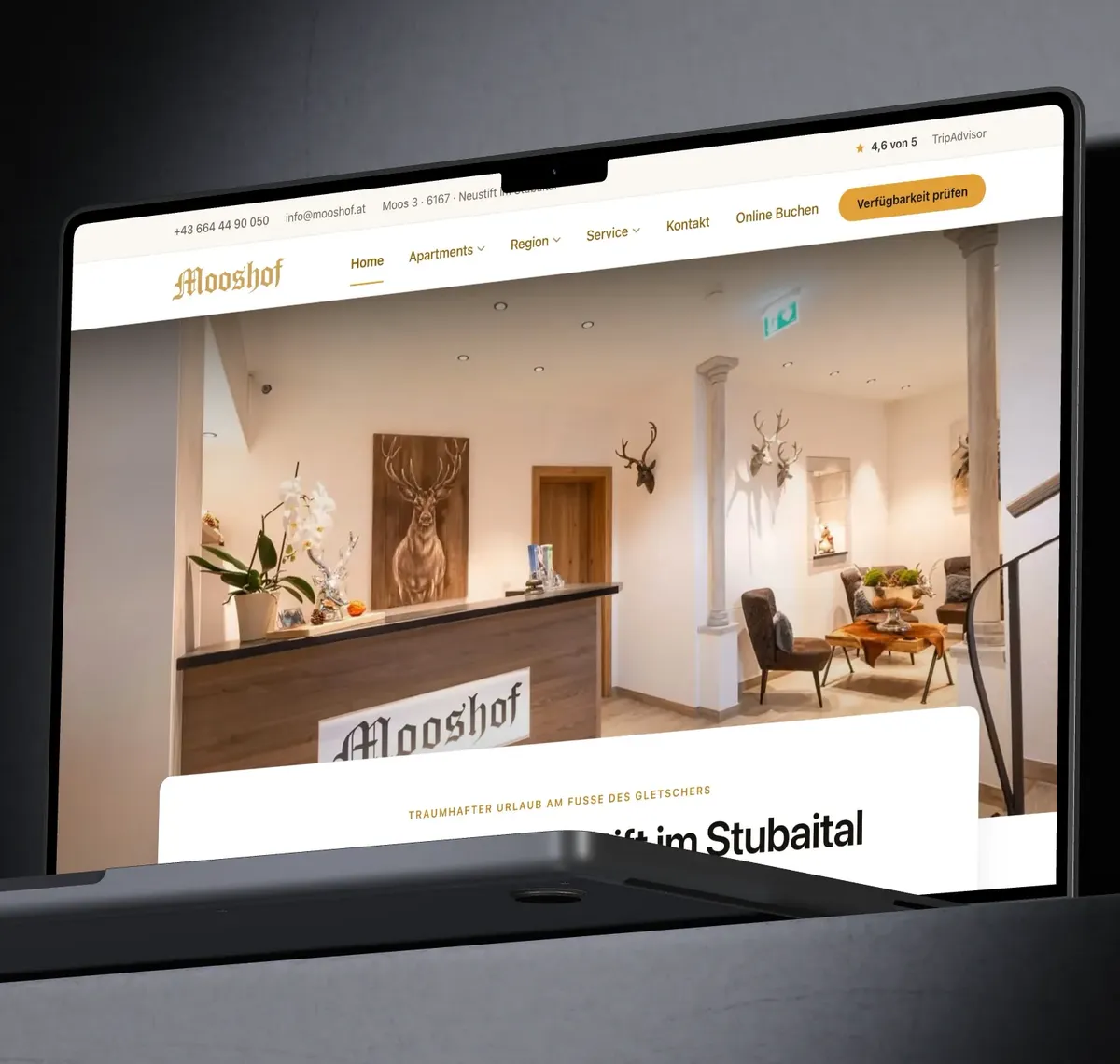 Apartmenthaus Mooshof: Ein MacBook Pro zeigt die Startseite von mooshof.at mit der Rezeption des Apartmenthauses.