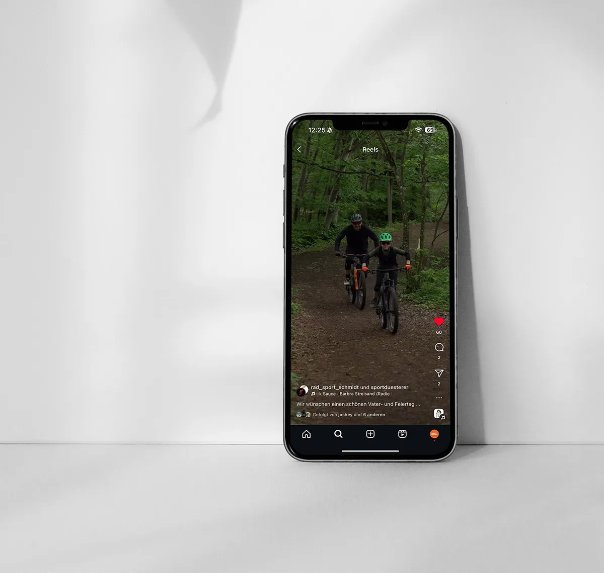 Rad Sport Schmidt: Smartphone vor weißem Hintergrund zeigt einen Instagram-Beitrag mit zwei Mountainbikern im Wald