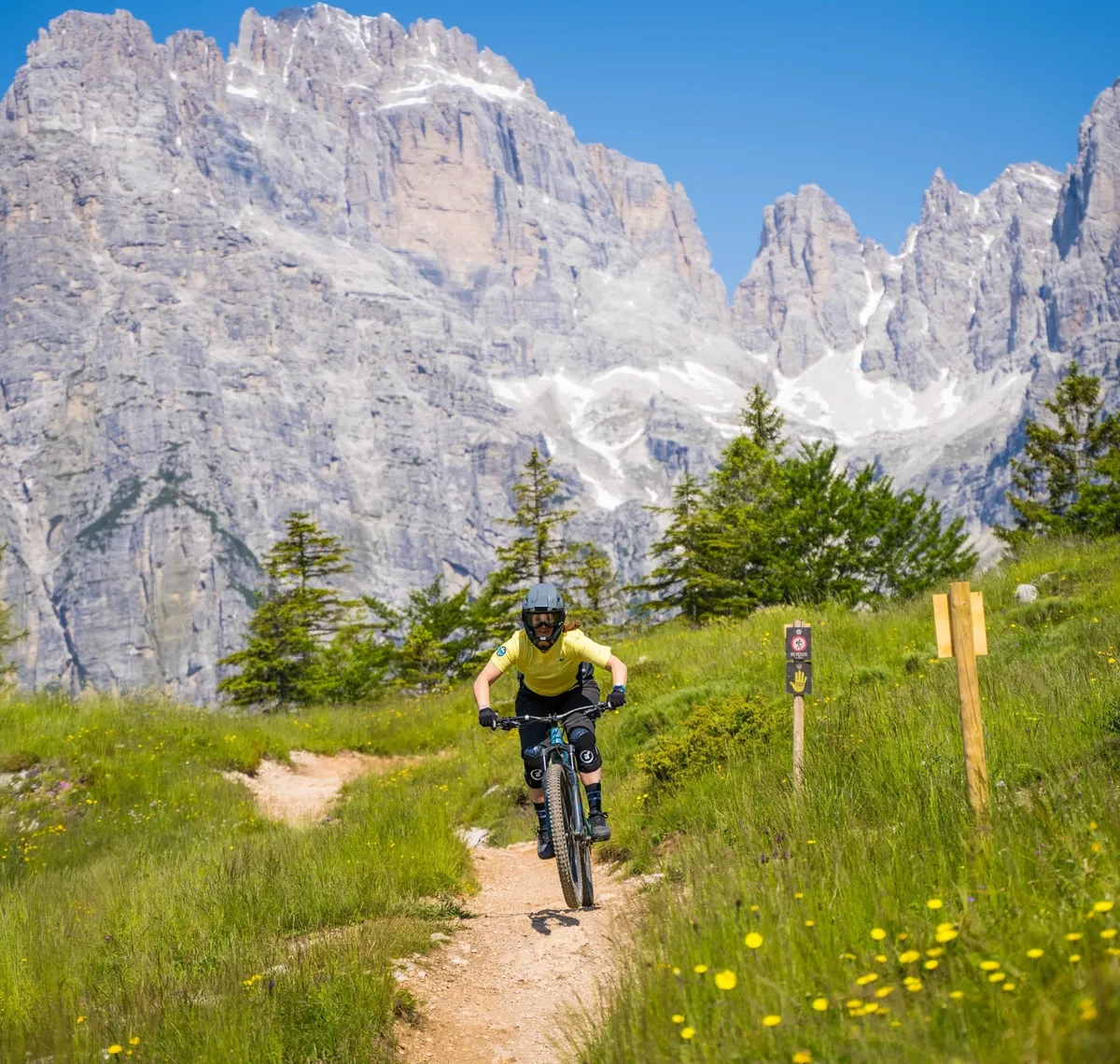Bike Women Camp: Mountainbiker auf einem Wiesentrail vor der Felswand der Dolomiten