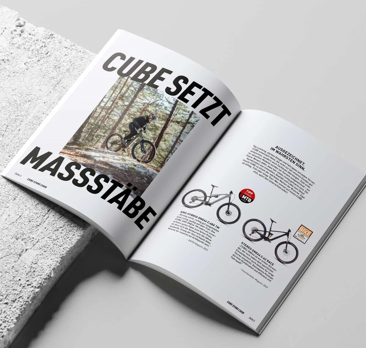 CUBE STORE CHUR: Aufgeschlagenes Magazin mit der Doppelseite „Cube setzt Maßstäbe" und einer Modellübersicht