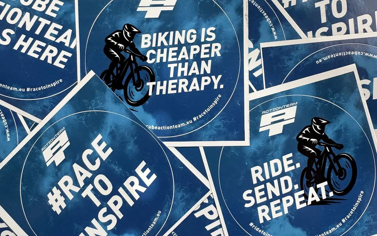 Sticker Design: Stapel runder Sticker des CUBE Actionteams mit Sprüchen wie „Biking is cheaper than therapy" und „Race to inspire"