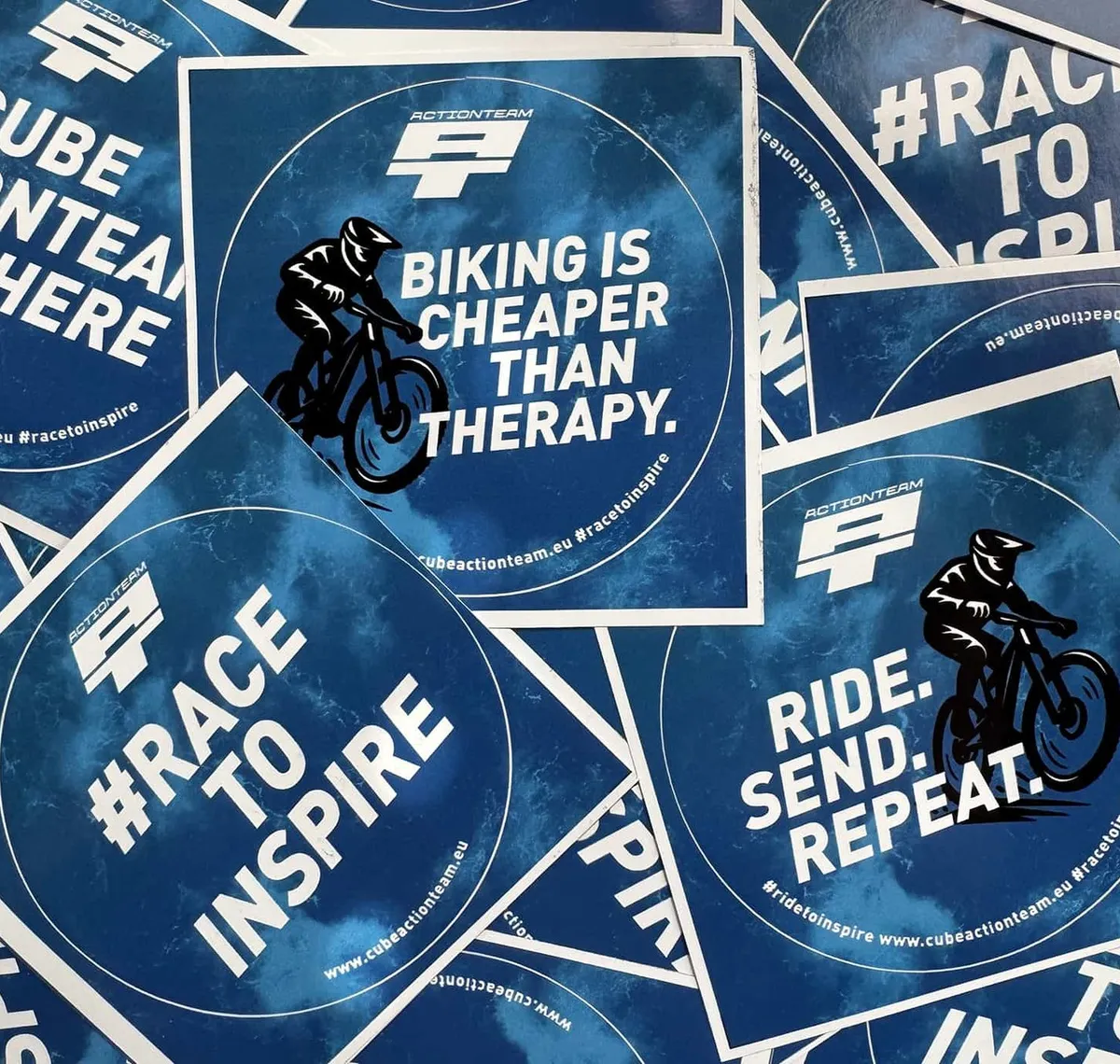 CUBE Actionteam: Stapel runder Sticker des CUBE Actionteams mit Sprüchen wie „Biking is cheaper than therapy" und „Race to inspire"