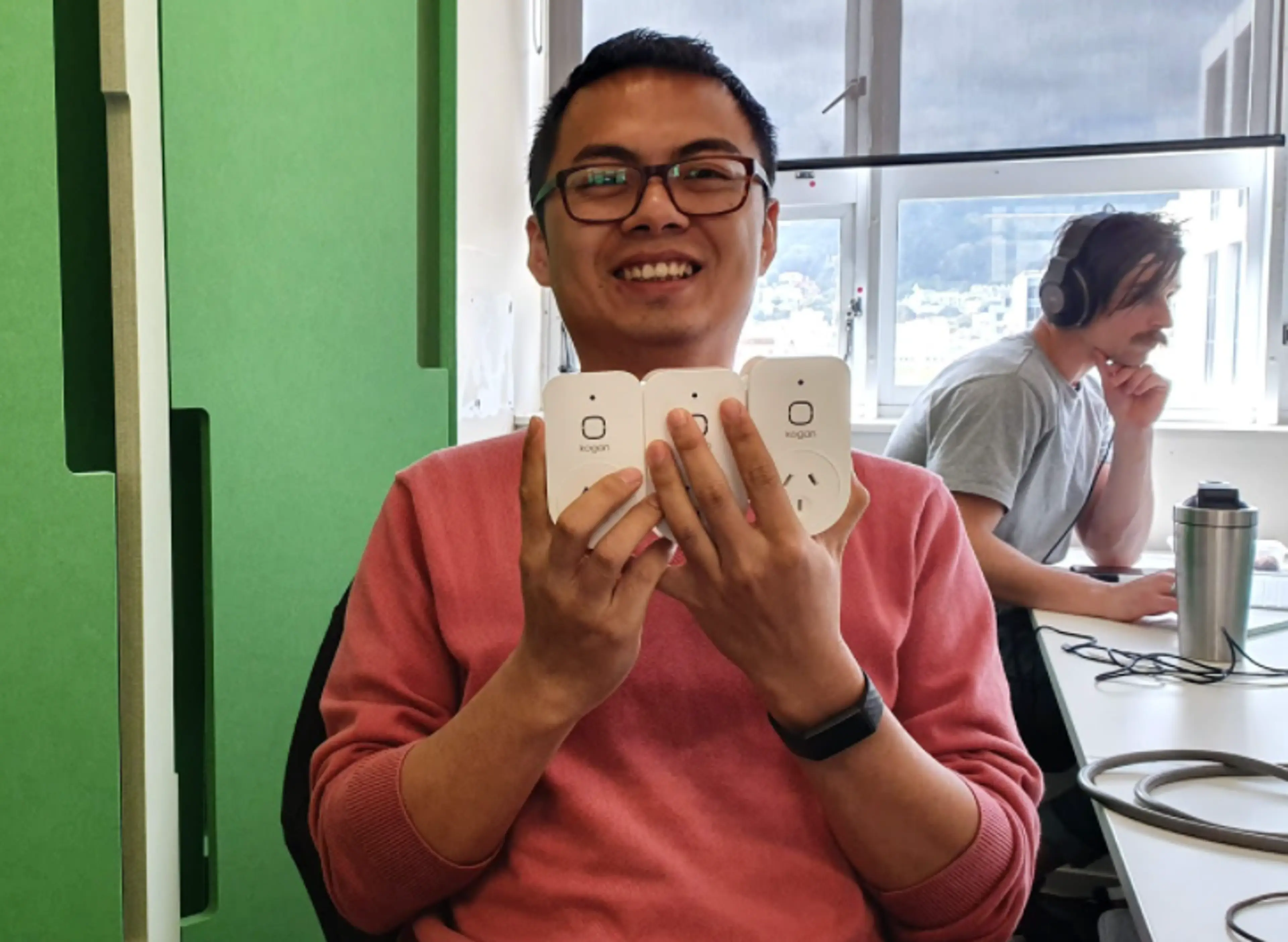Fanchao is smiling while showing various smart plugs.