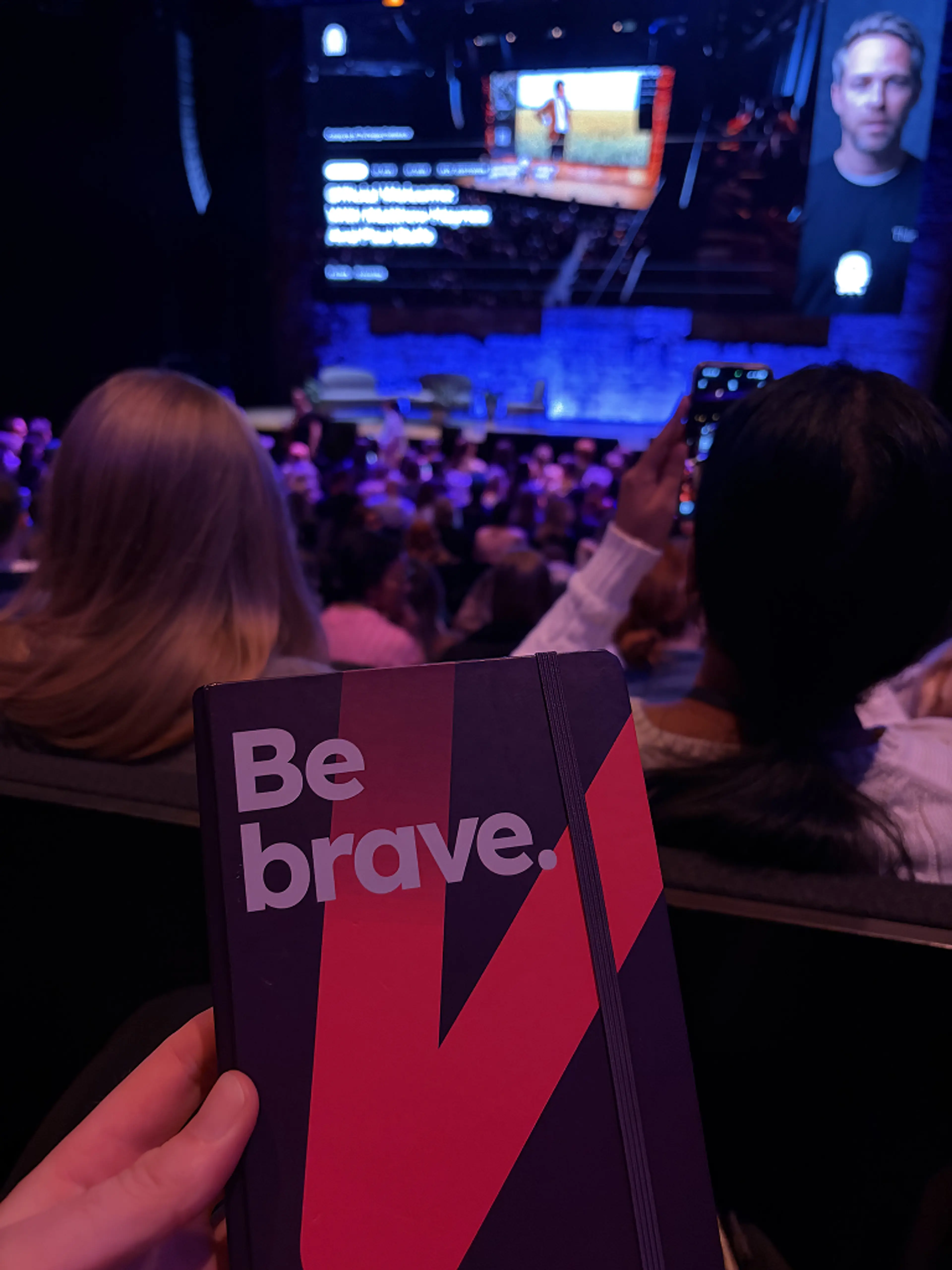 Hand holding book in front of stage