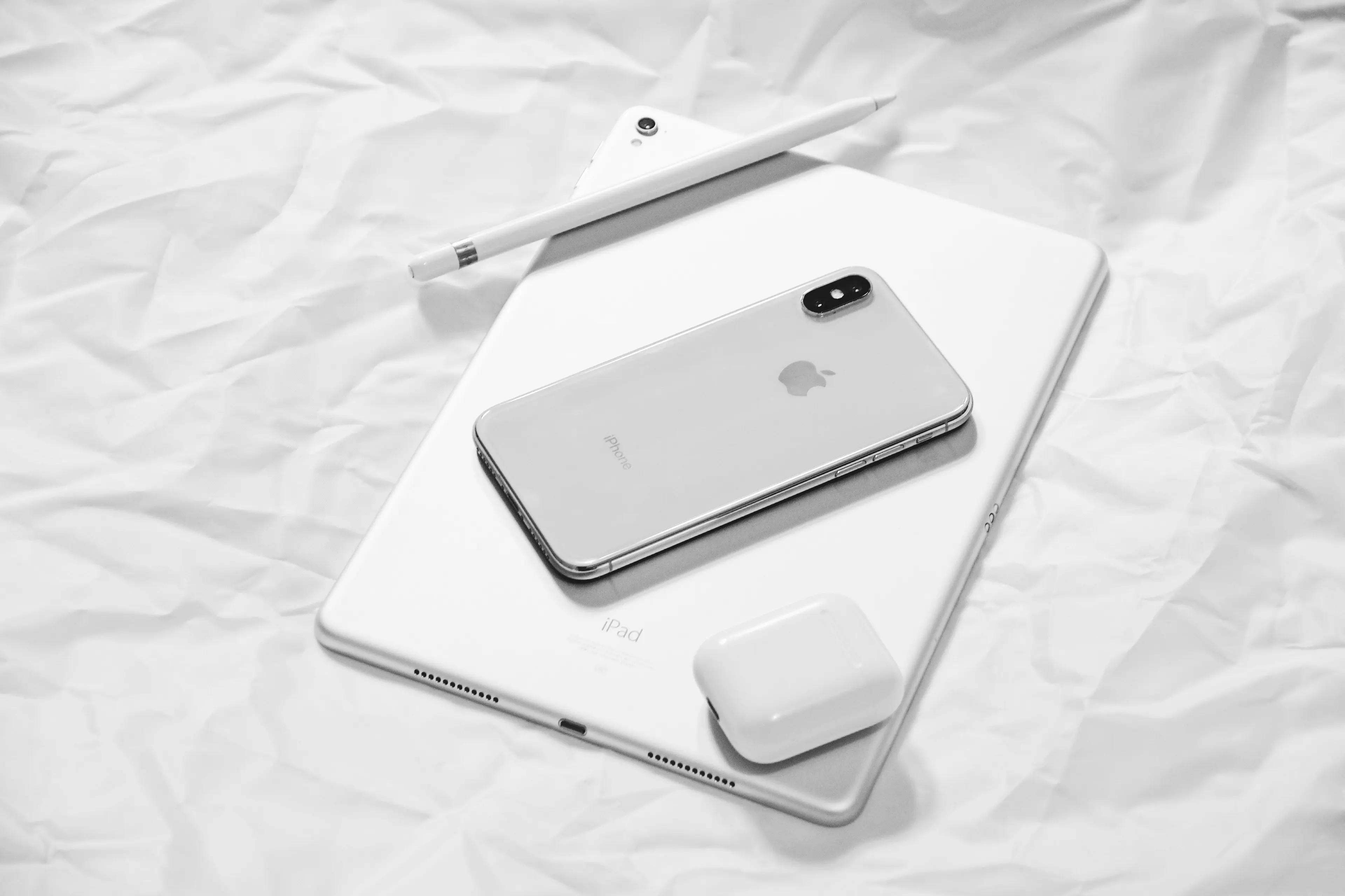 Apple tablet, iPhone and ear buds. Photo by Xiong Yan on Unsplash