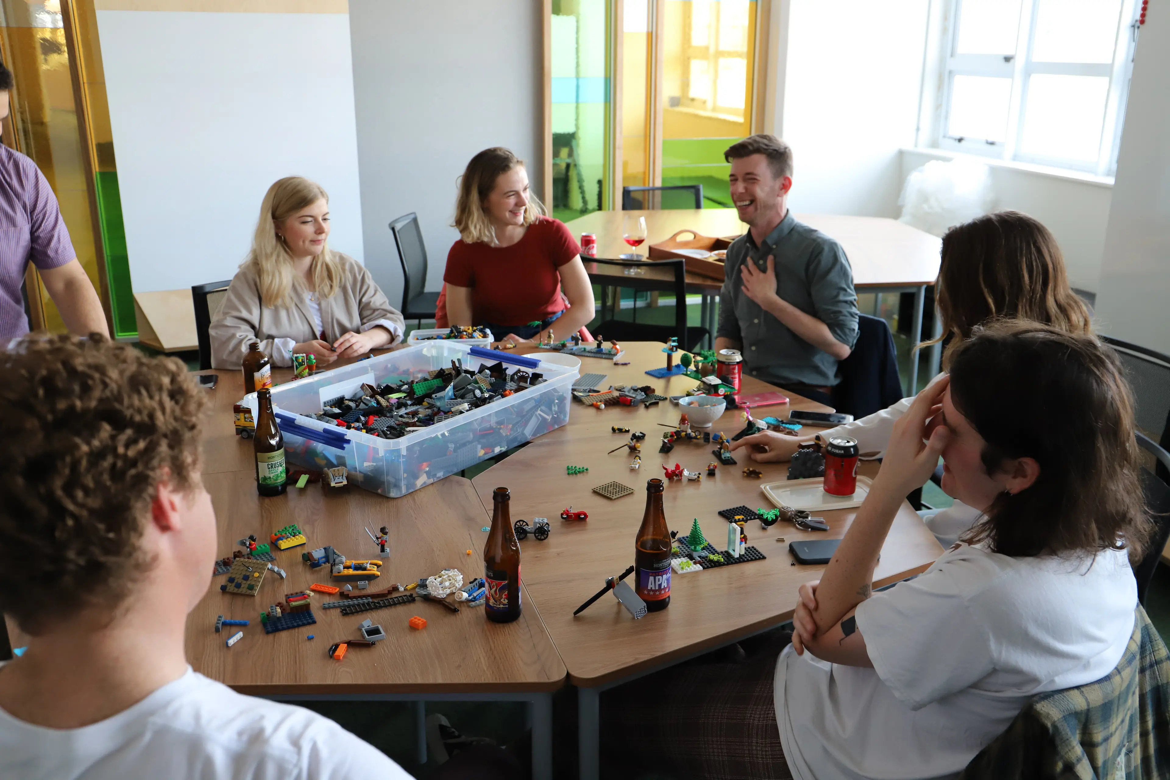 Group of people playing lego on a round table