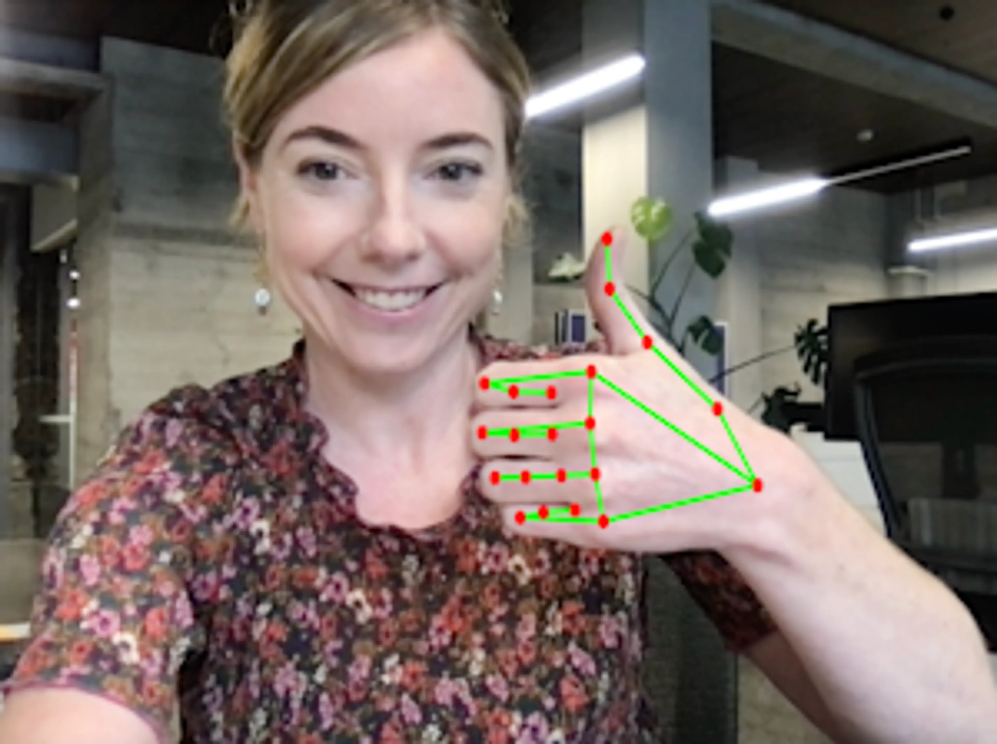 Smiling woman with her thumb up, demonstrating MediaPipe Hands