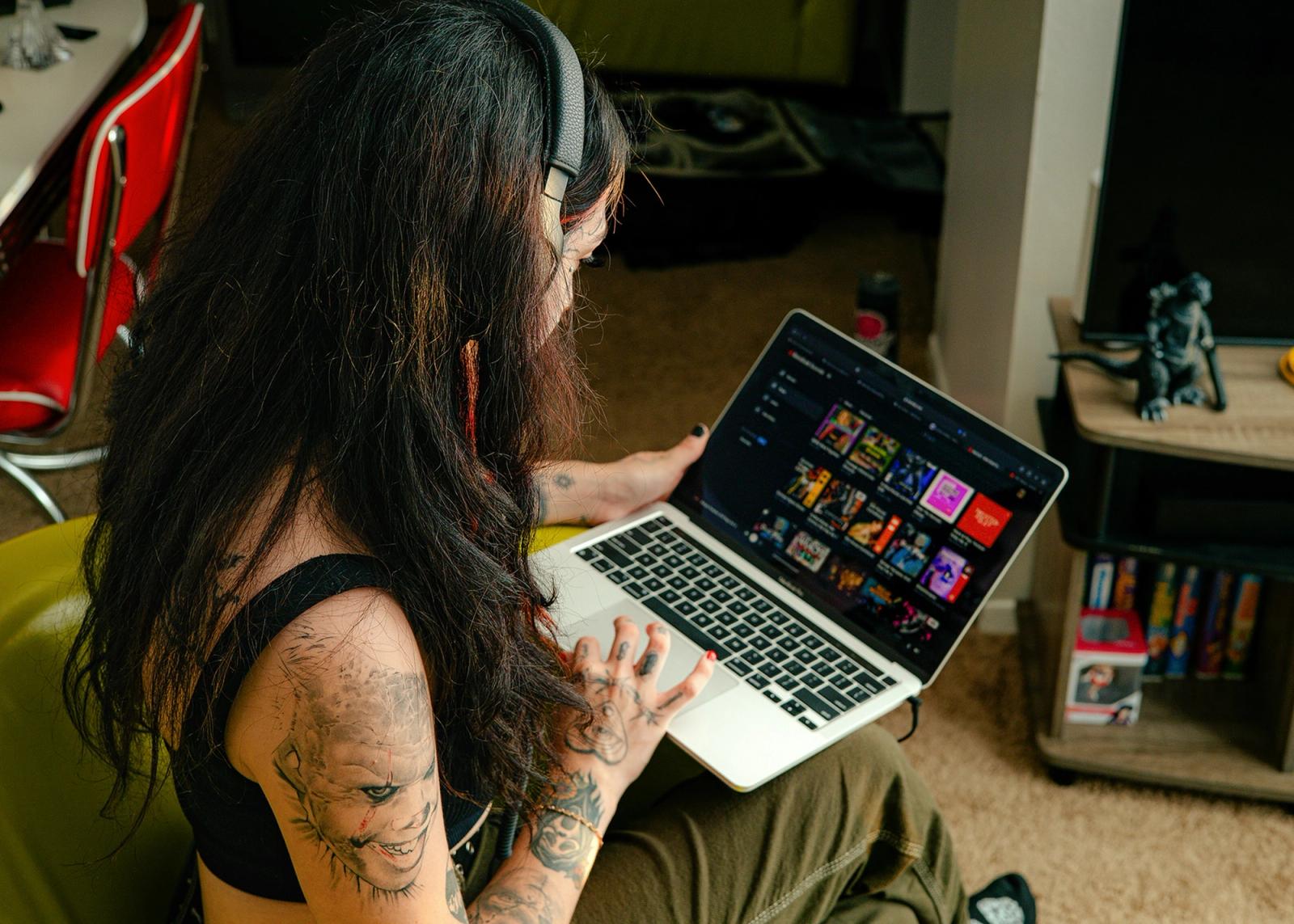 girl working on a laptop wearing headphones