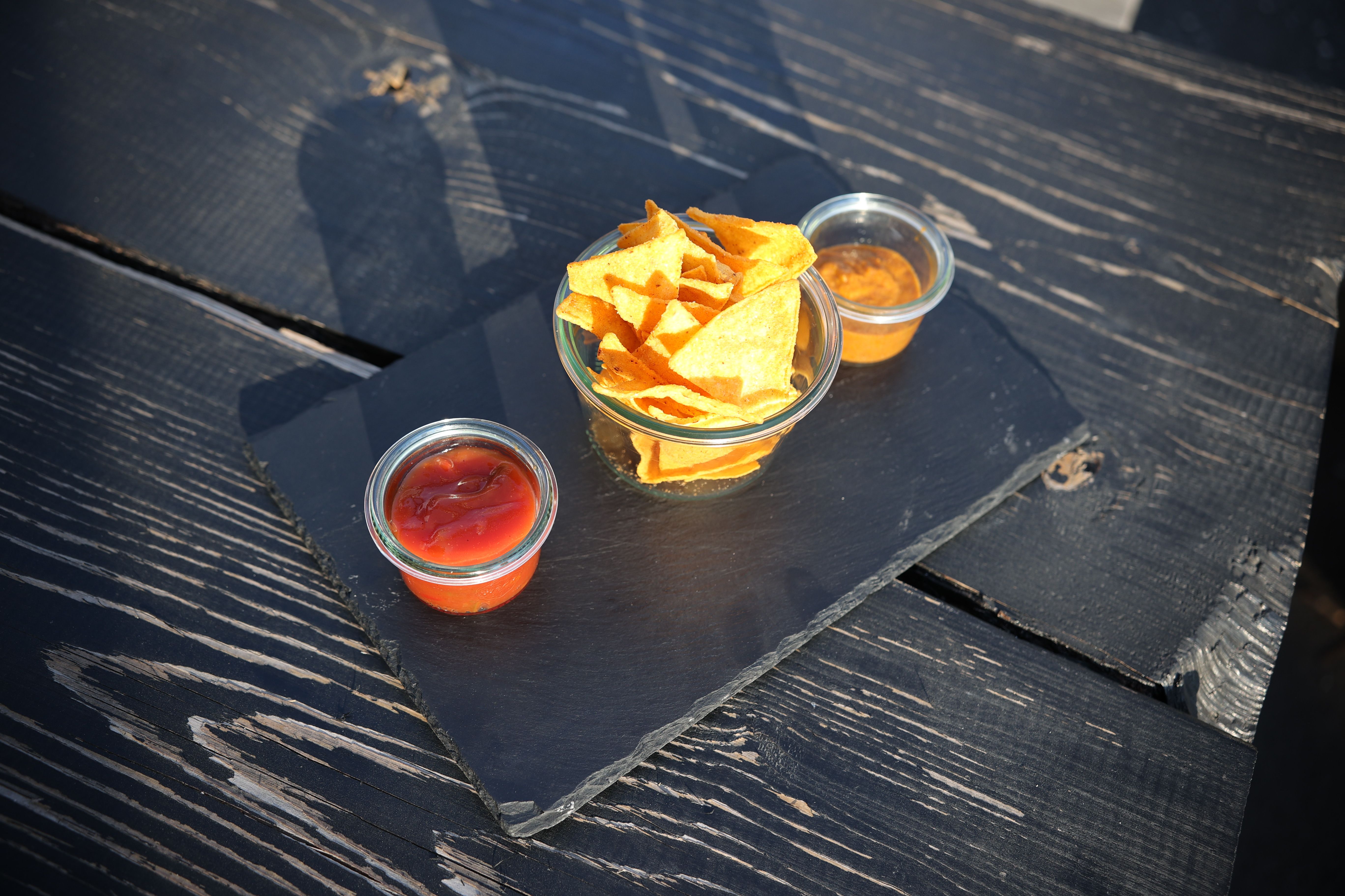 Nachos mit Salsa und Käsedip – Tortilla-Chips mit zwei hausgemachten Saucen auf Schieferplatte, Porto Bar Gratwein