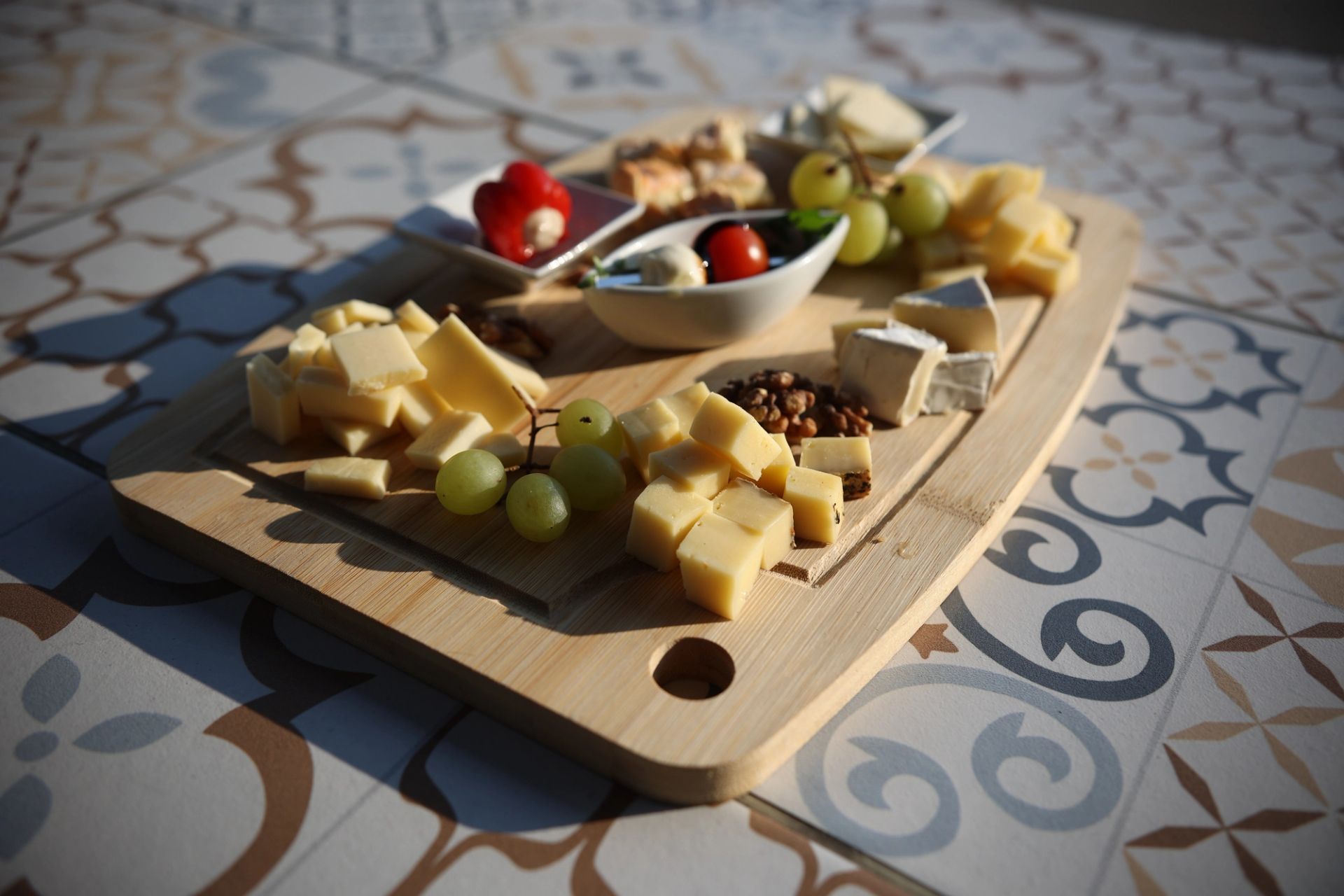 Käsevariation – Ausgewählte Käsesorten mit Trauben, Walnüssen und Brot auf Holzbrett, Porto Bar Gratwein