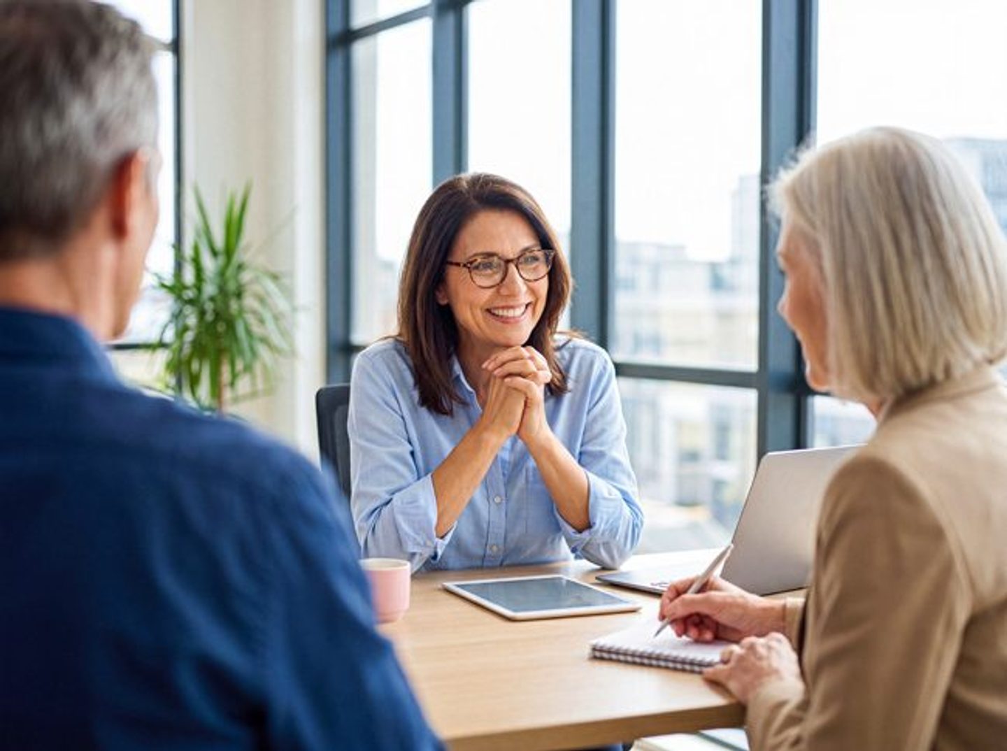 An advisor gives a couple real, undivided attention in an office — the segment-of-one experience