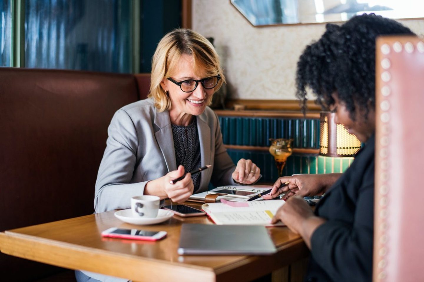 A small team of colleagues works together in a booth — the deliberate starting team an RIA should begin with