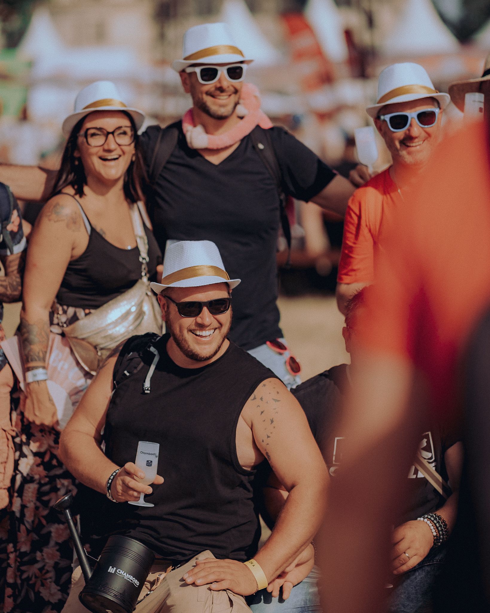 Festivaliers souriants en chapeaux blancs et lunettes de soleil à Chambord Live