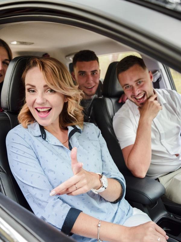 Quatre amis souriants dans une voiture pour le covoiturage vers Chambord Live