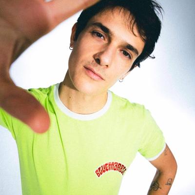 Portrait de Kungs en t-shirt vert fluo, la main tendue vers l'objectif