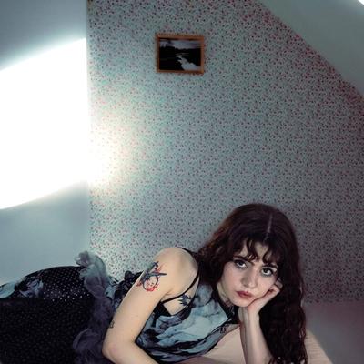 Portrait de Jane et les autres, la chanteuse allongée sur un lit sous une mansarde