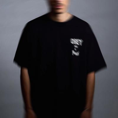Portrait flou de Raffa Guido, debout en t-shirt noir sur fond gris