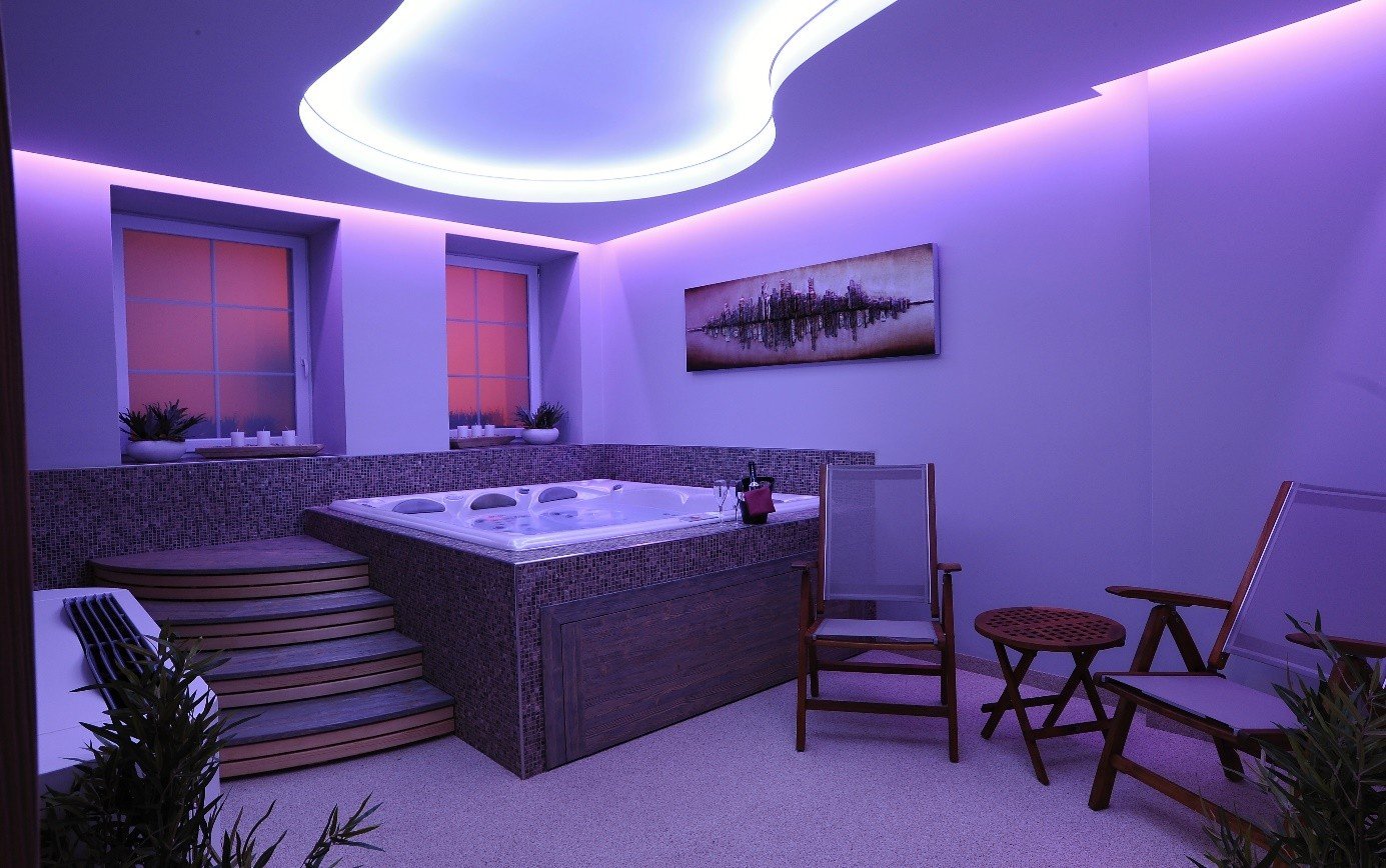 Whirlpool with lit water and candles in the window, the smaller private wellness at Jarmilka