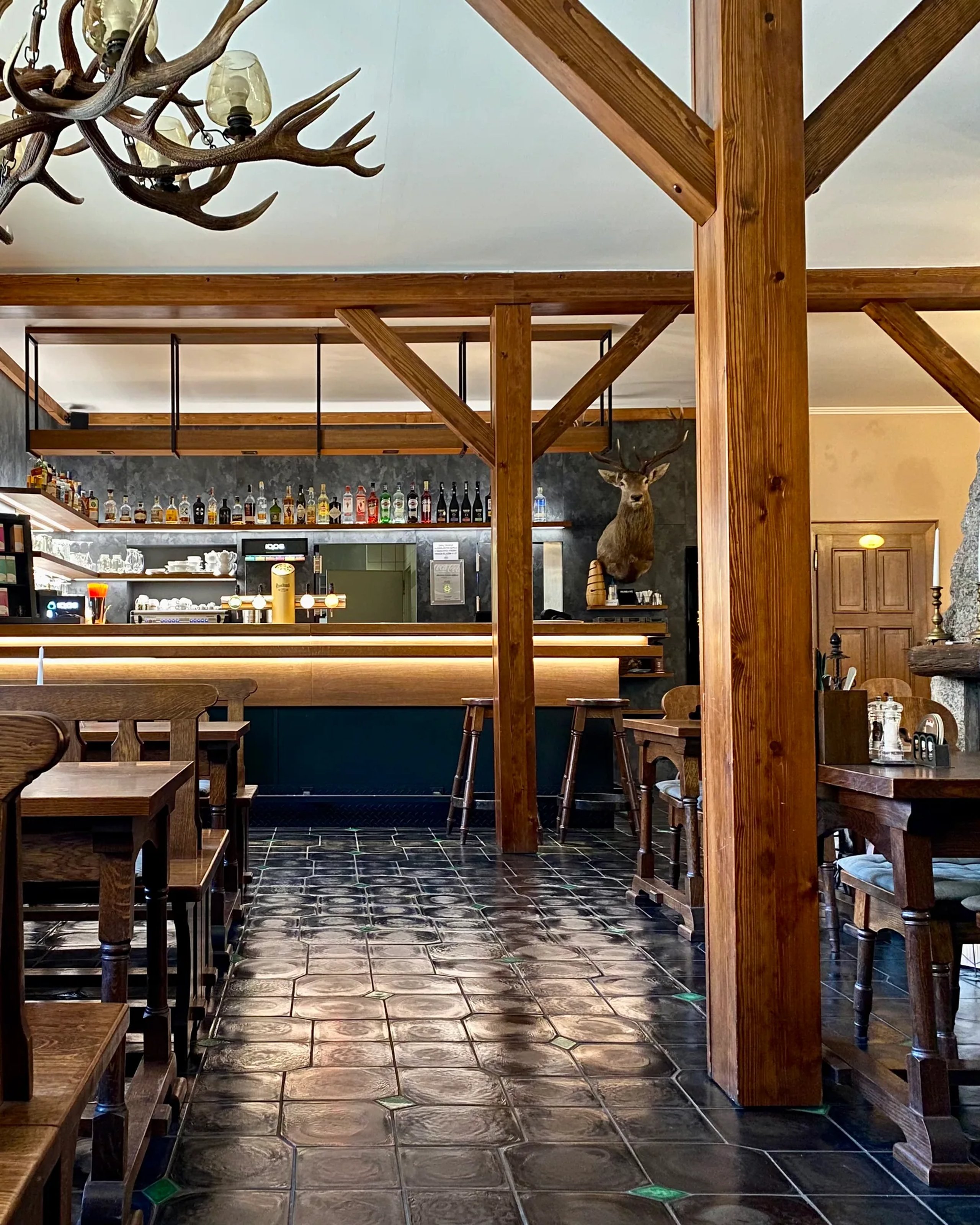 Restaurace penzionu Jarmilka s dřevěnými trámy a barem