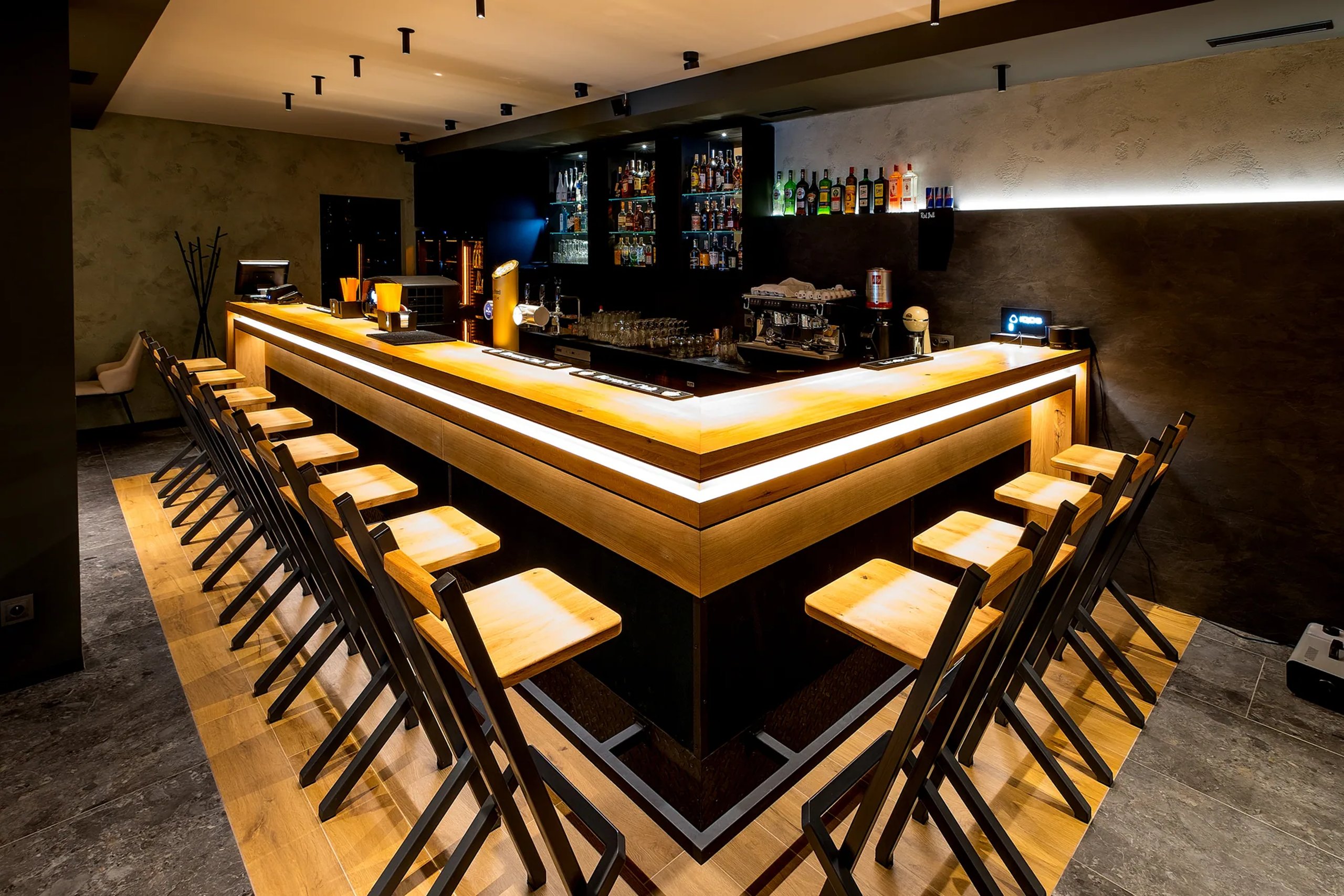 The lit bar counter with oak stools at the Jarmilka guesthouse