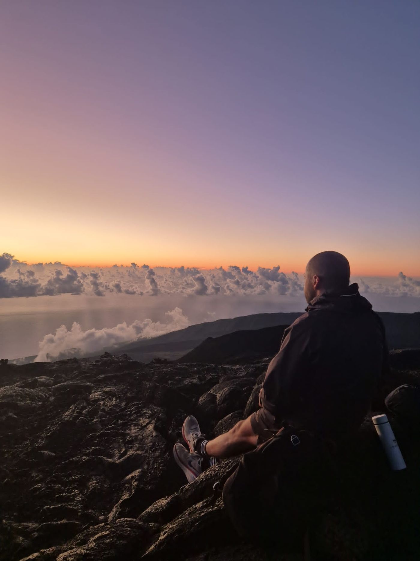 Philippe face à la mer de nuages au coucher du soleil, sur les hauteurs de La Réunion.