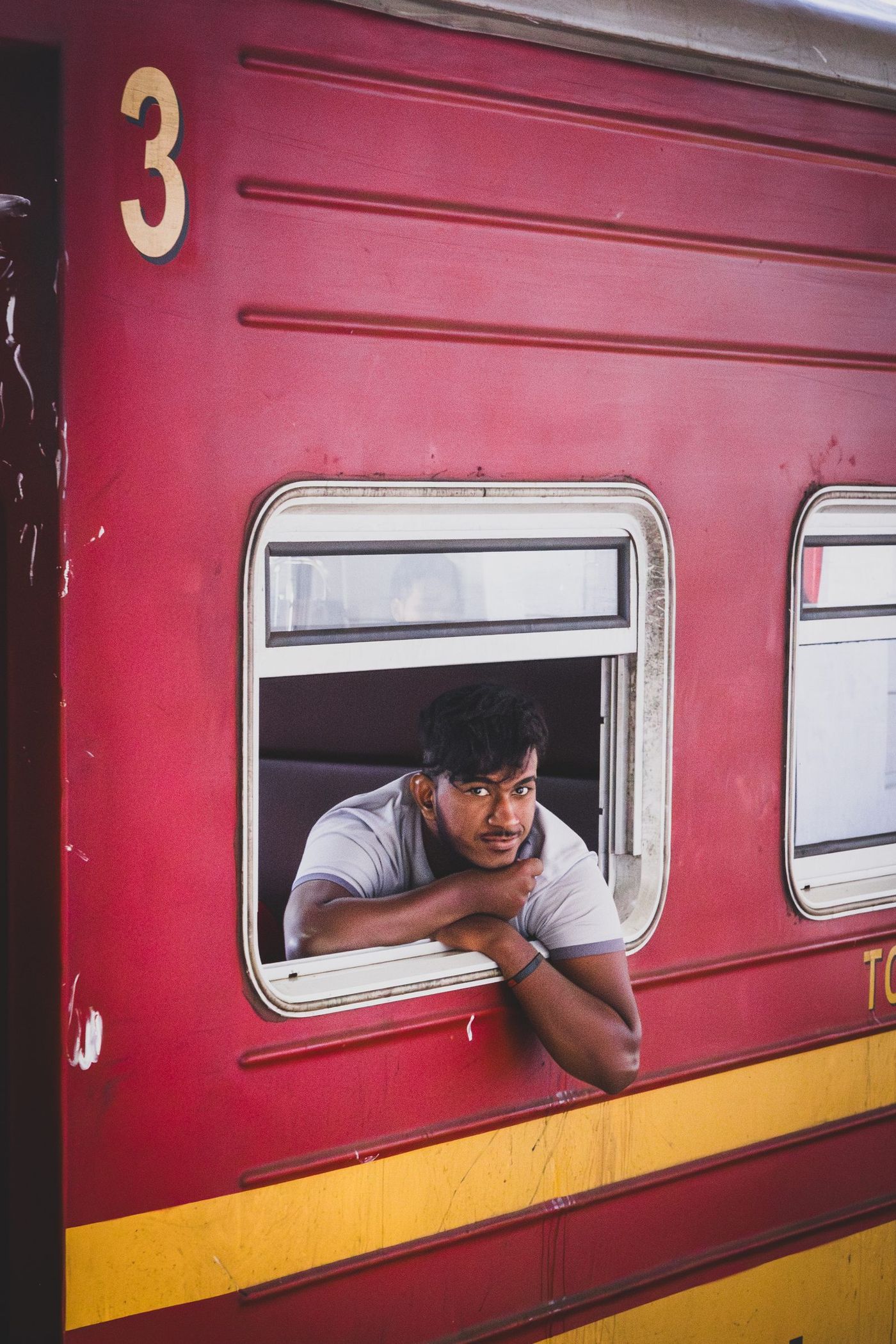 Un habitante sonriente en la ventana de un tren local en Sri Lanka.