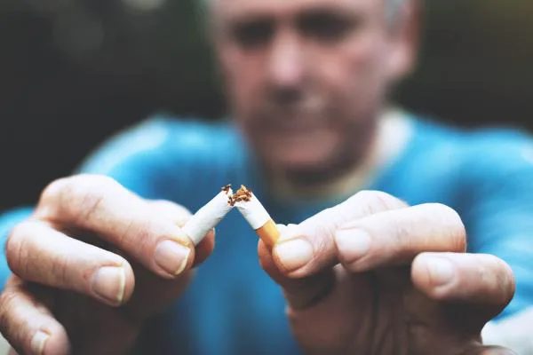 A close view of a hand breaking a cigarette.