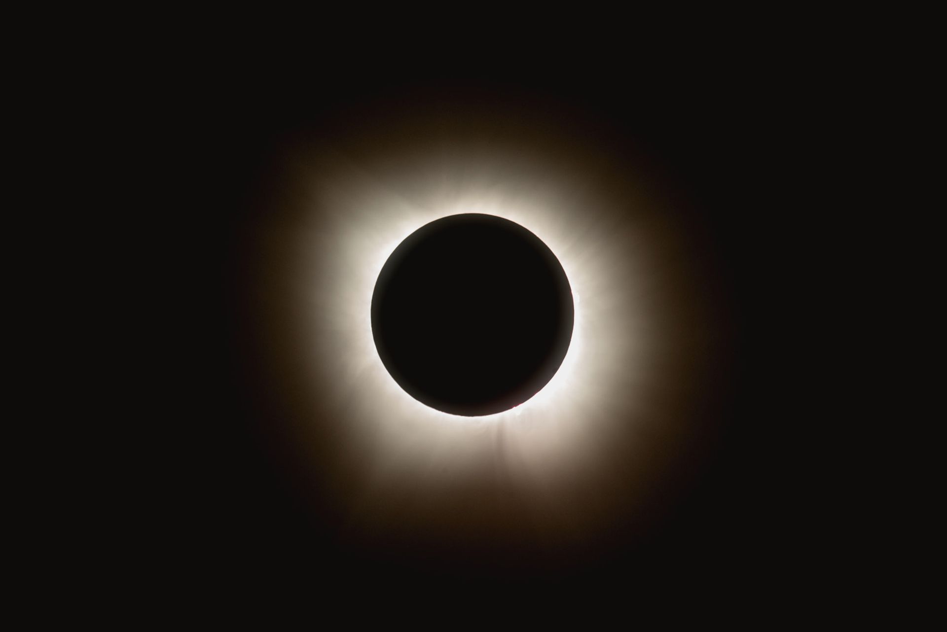 The Sun's white corona surrounds the black disc of the Moon during a total solar eclipse