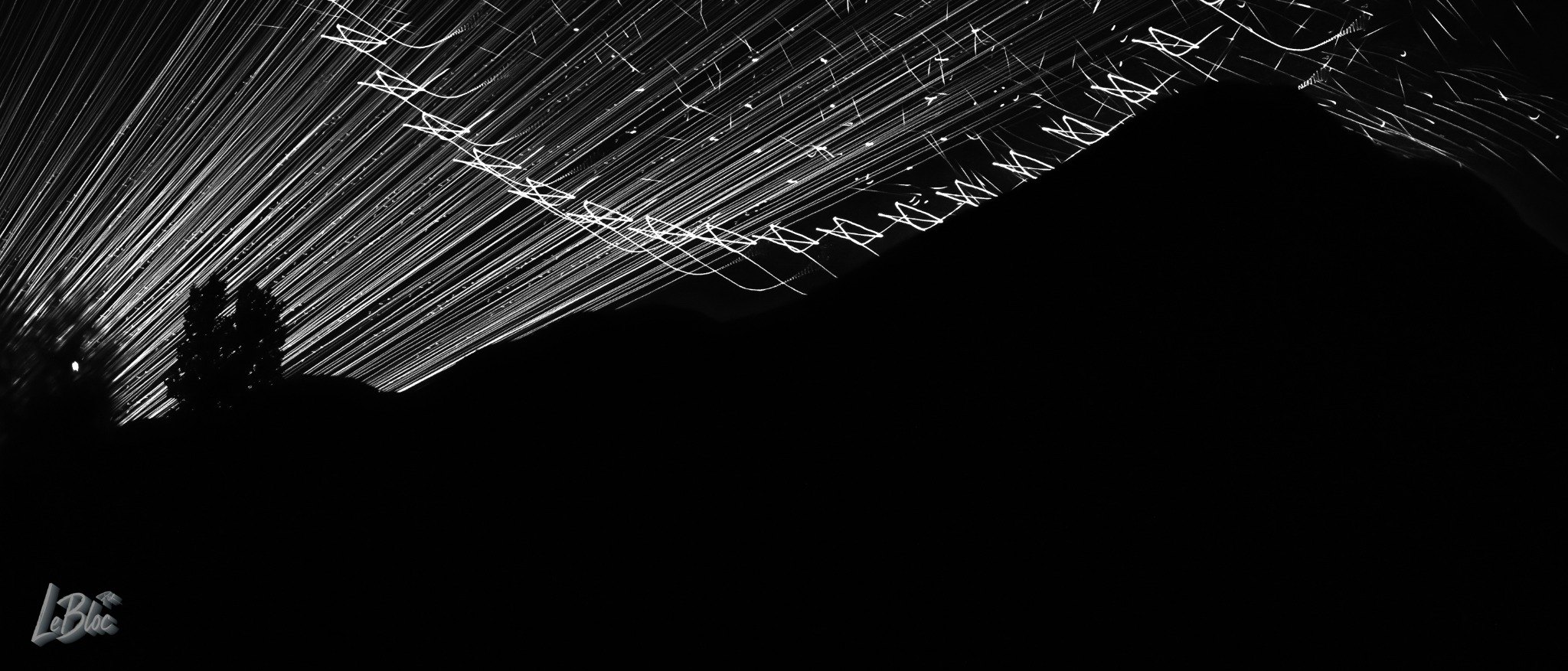 A broad silver arc sweeps over a black architectural silhouette