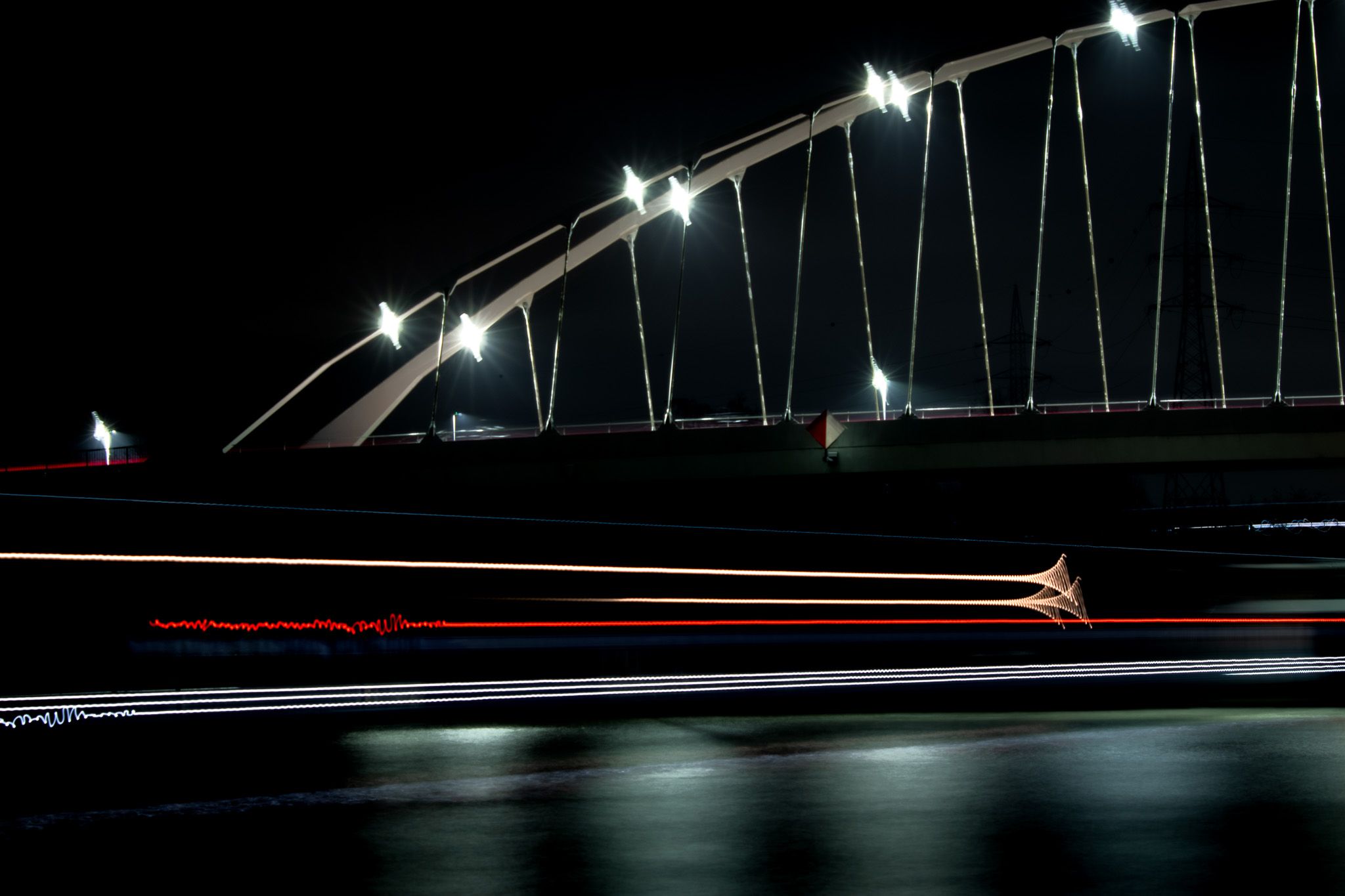White bridge structure held above layered red and white traffic light