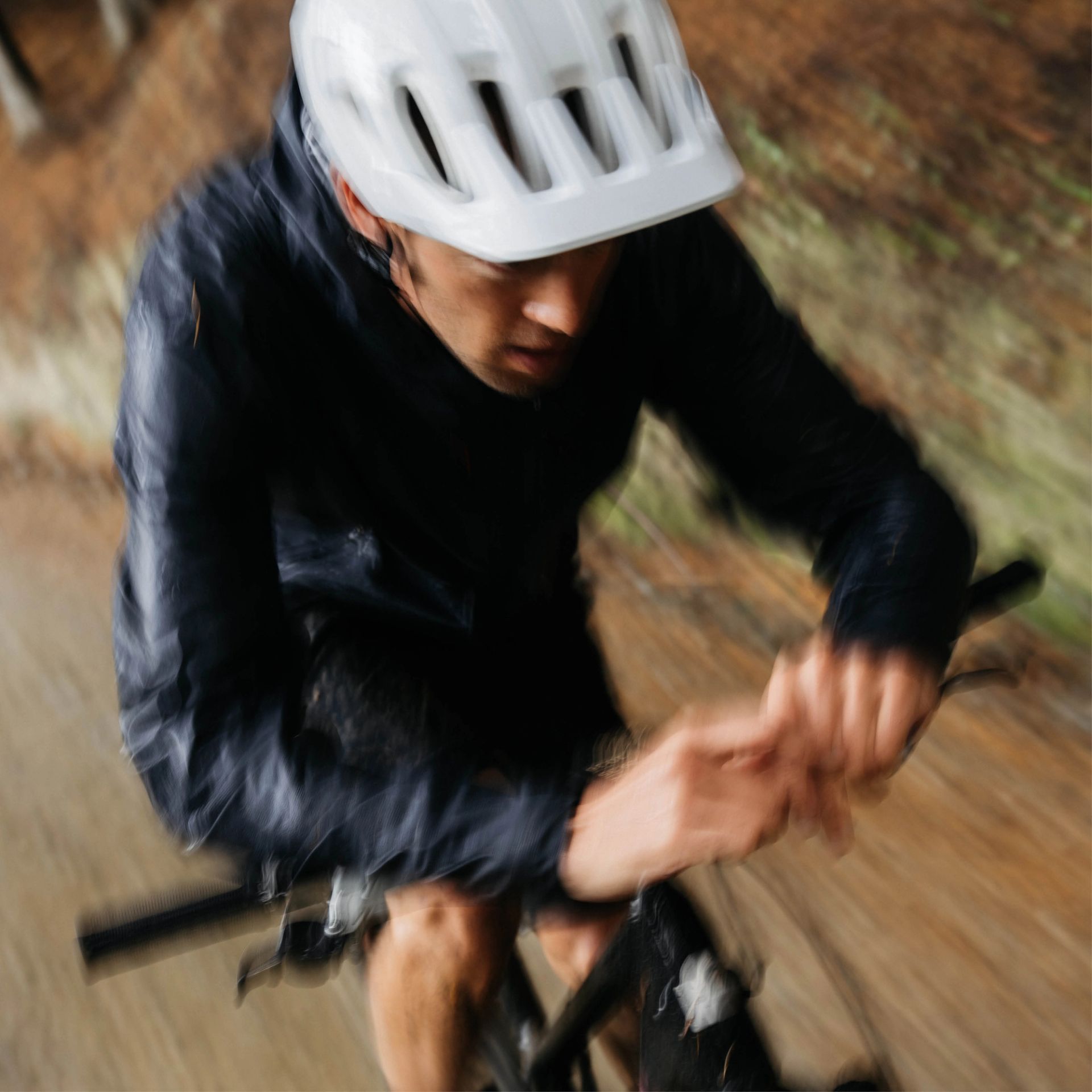 Ben Hildred cycling in rain wearing a white cularis helmet