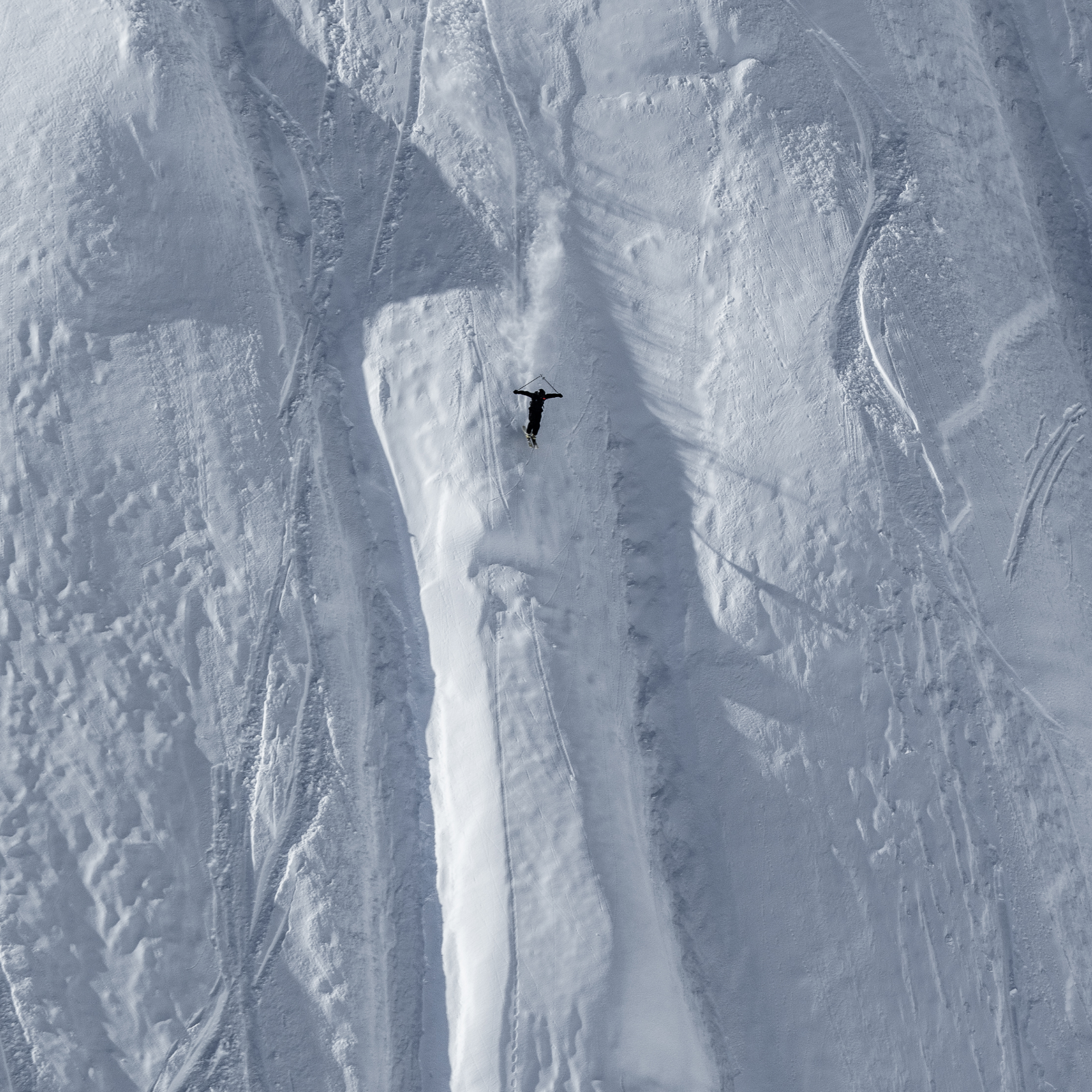 Skier skiing in very steep backcountry terrain