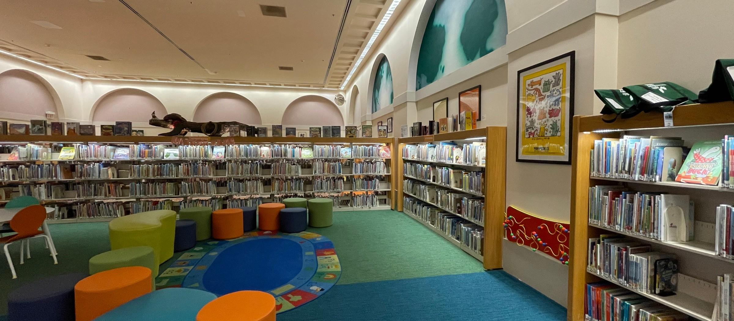 La sala infantil de la Main Library, con una alfombra redonda para cuentos, asientos de colores y estanterías altas