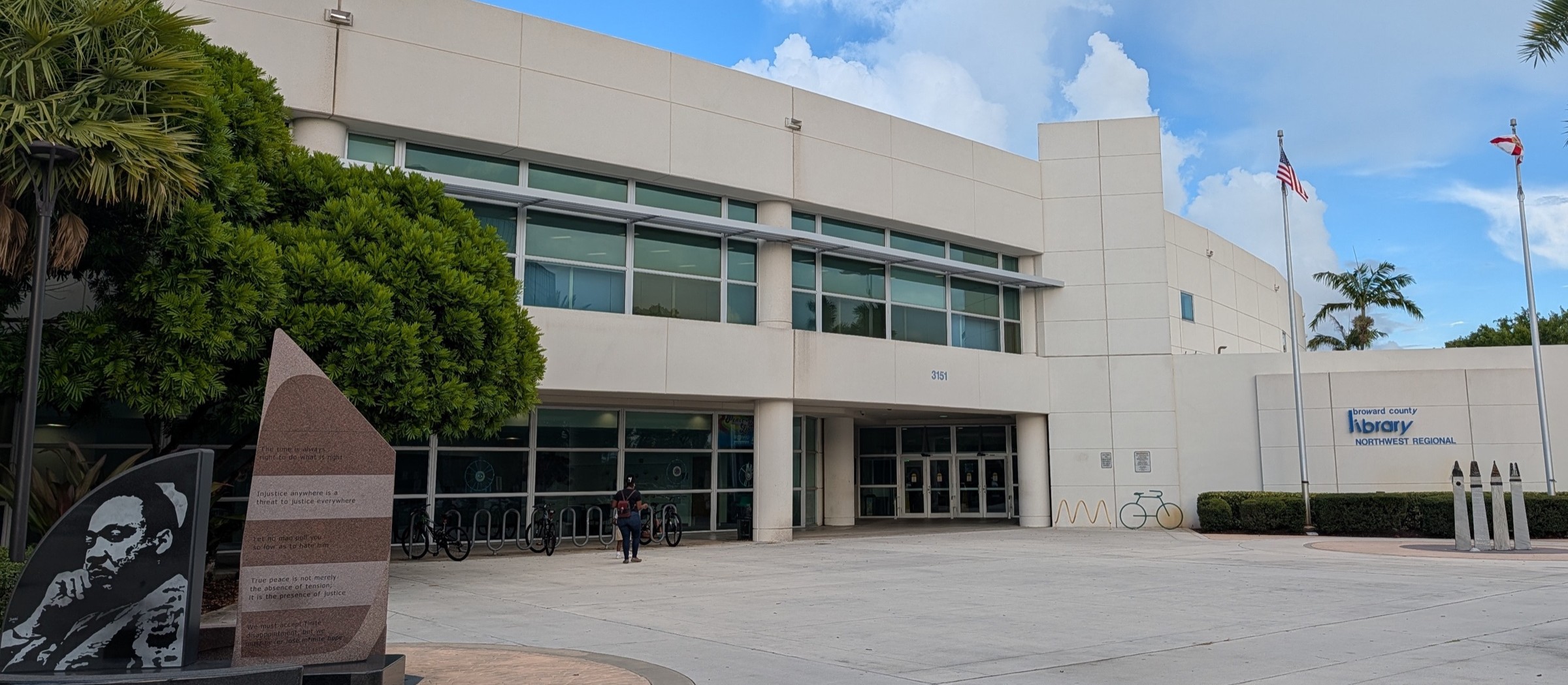 The Northwest Regional Library building in Coral Springs, with a stone monument in the front plaza