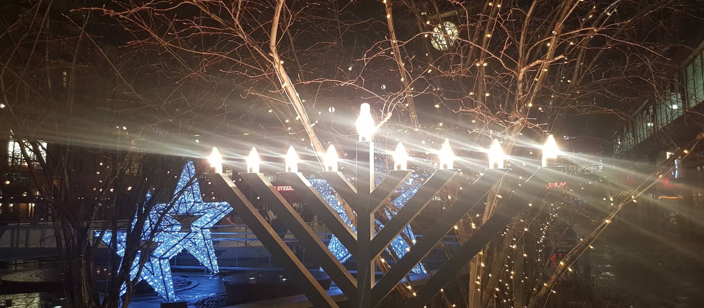 A large outdoor menorah with all its lights lit at night