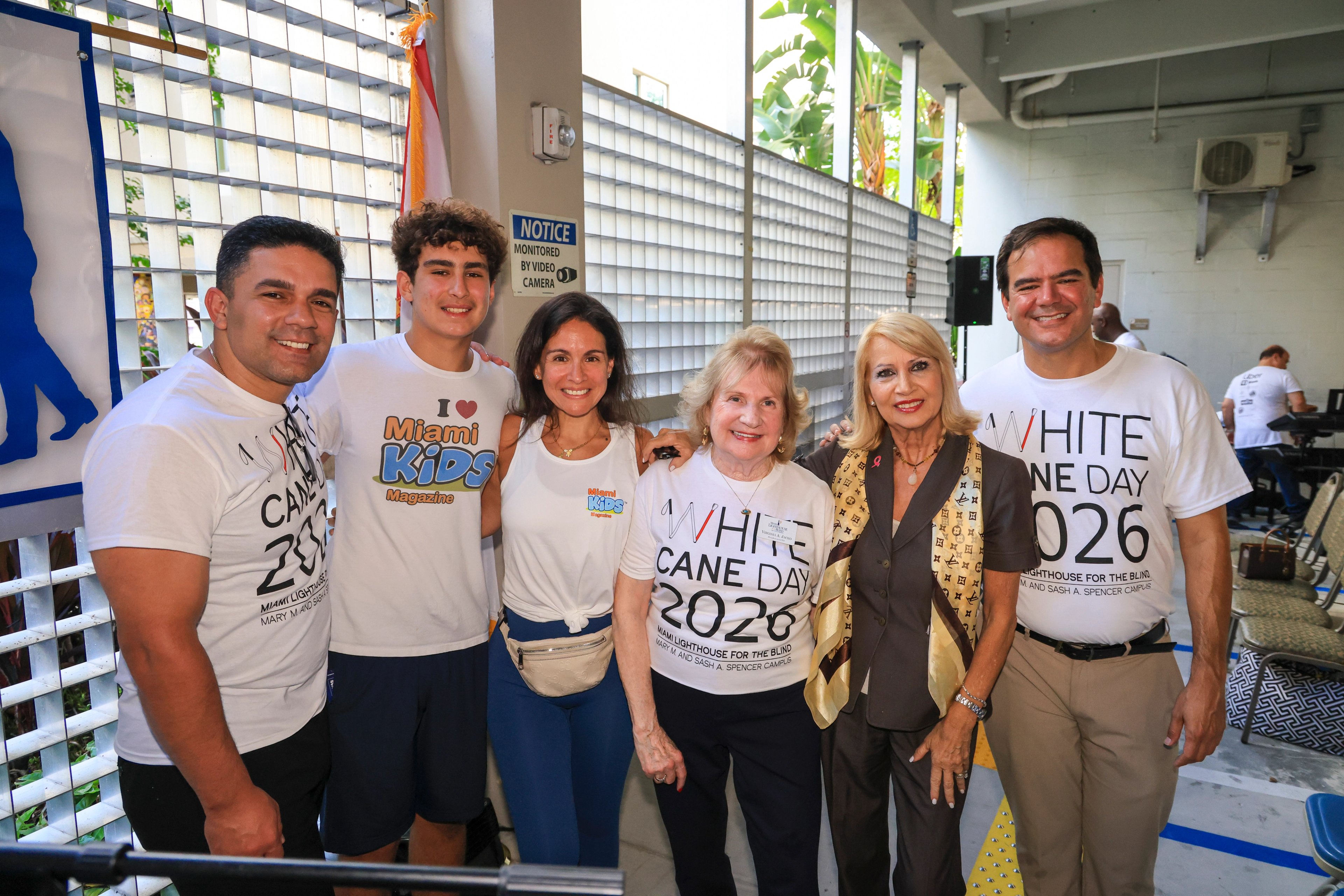 Seis invitados juntos, tres con camisetas del White Cane Day 2026 y dos con camisetas de Miami Kids Magazine