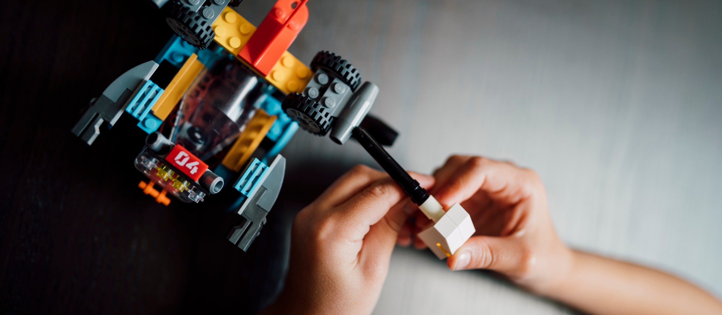 Las manos de un niño armando un vehículo de LEGO