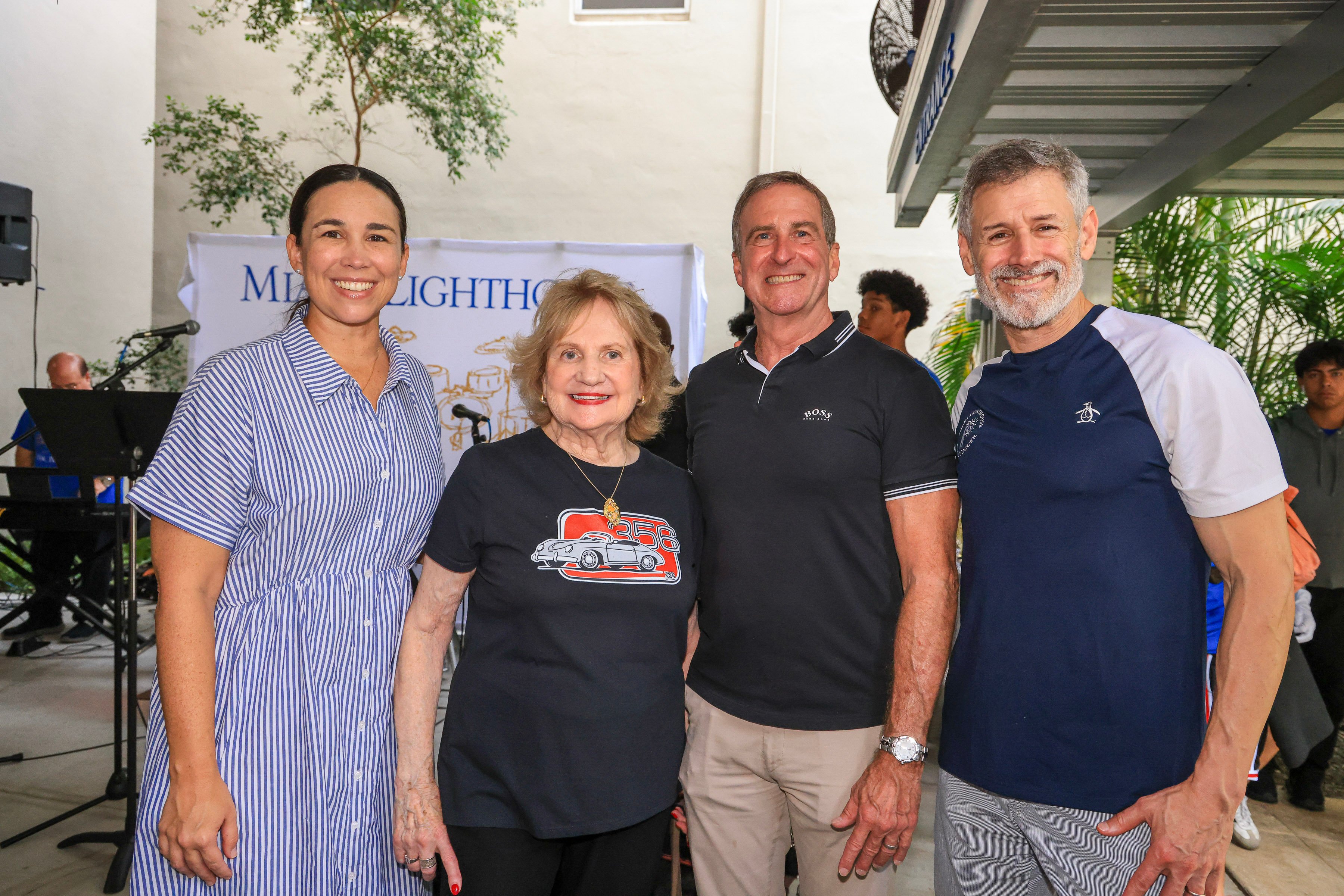 Cuatro miembros de la junta sonríen juntos ante una pancarta de Miami Lighthouse