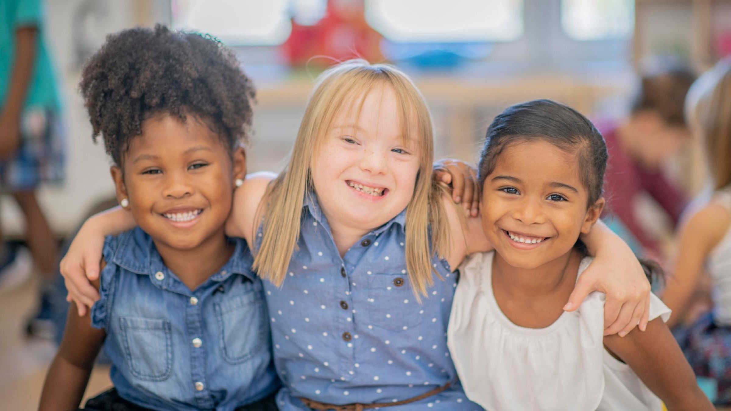Tres niñas sonrientes abrazadas