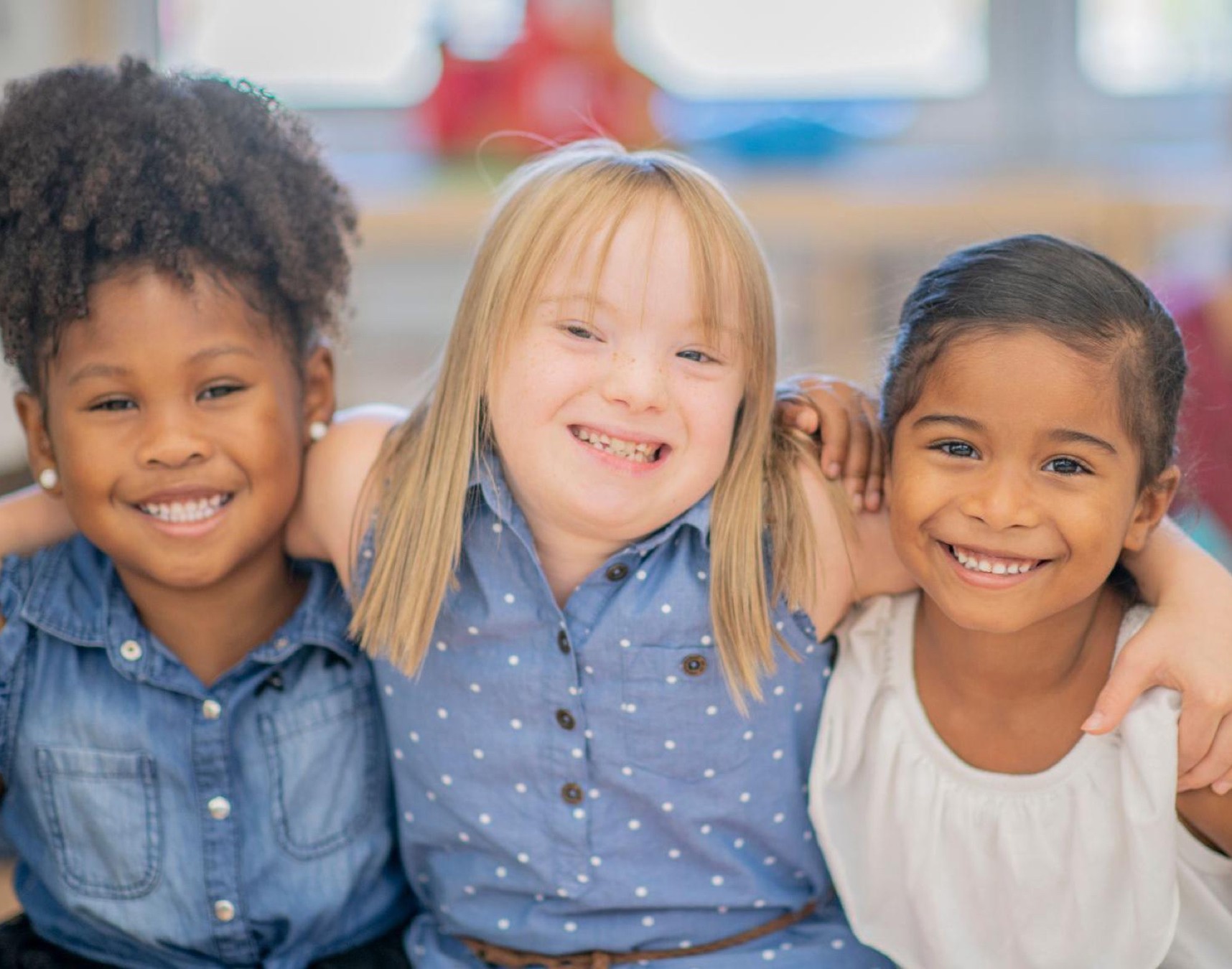 Three smiling girls with their arms around each other