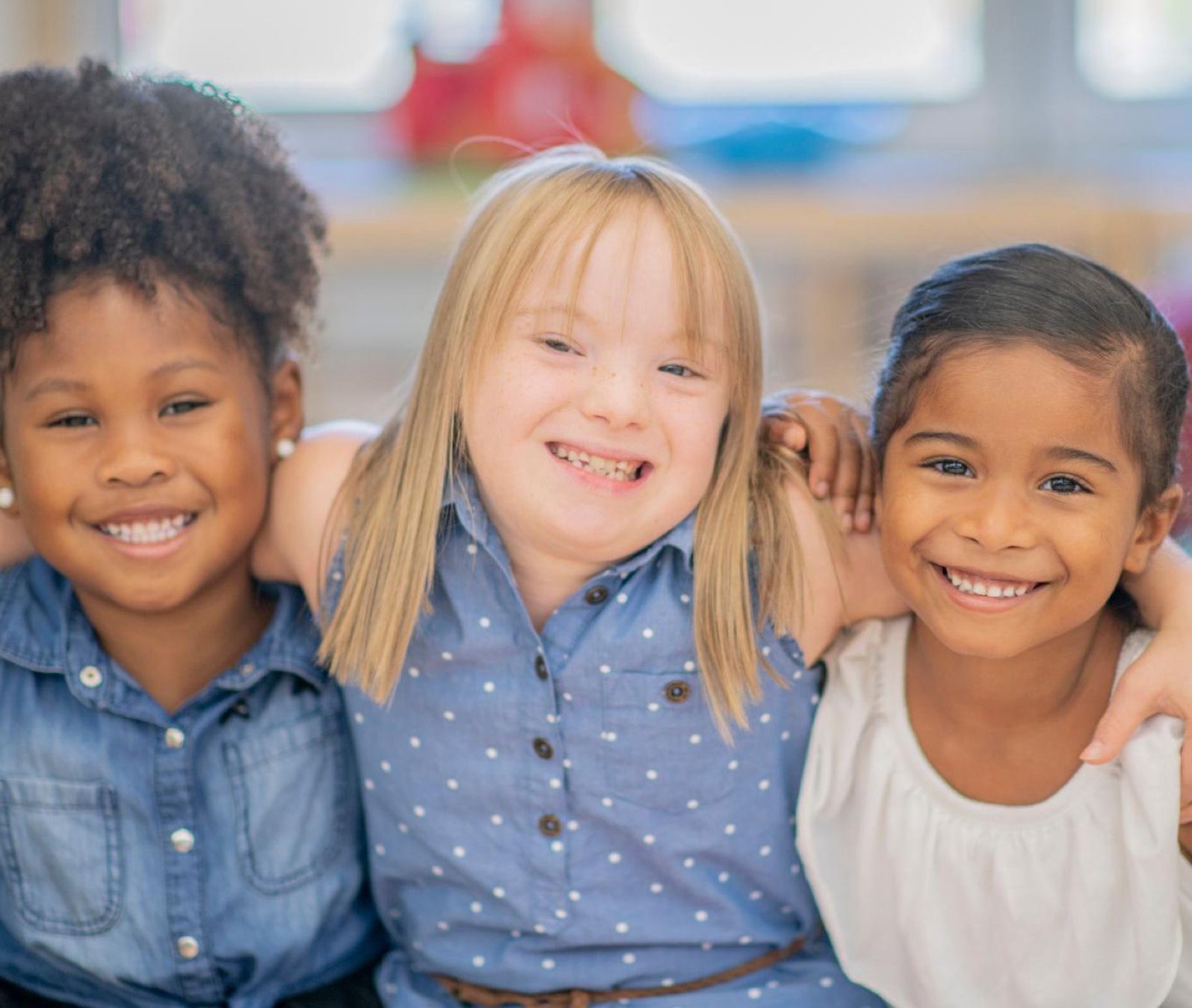 Tres niñas sonrientes abrazadas