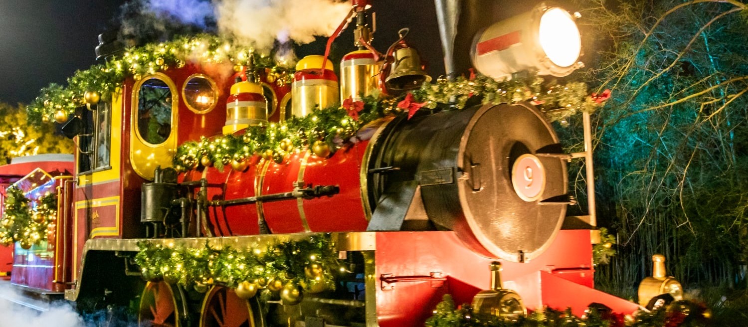 A steam locomotive decked with garlands and lights at Christmas Town